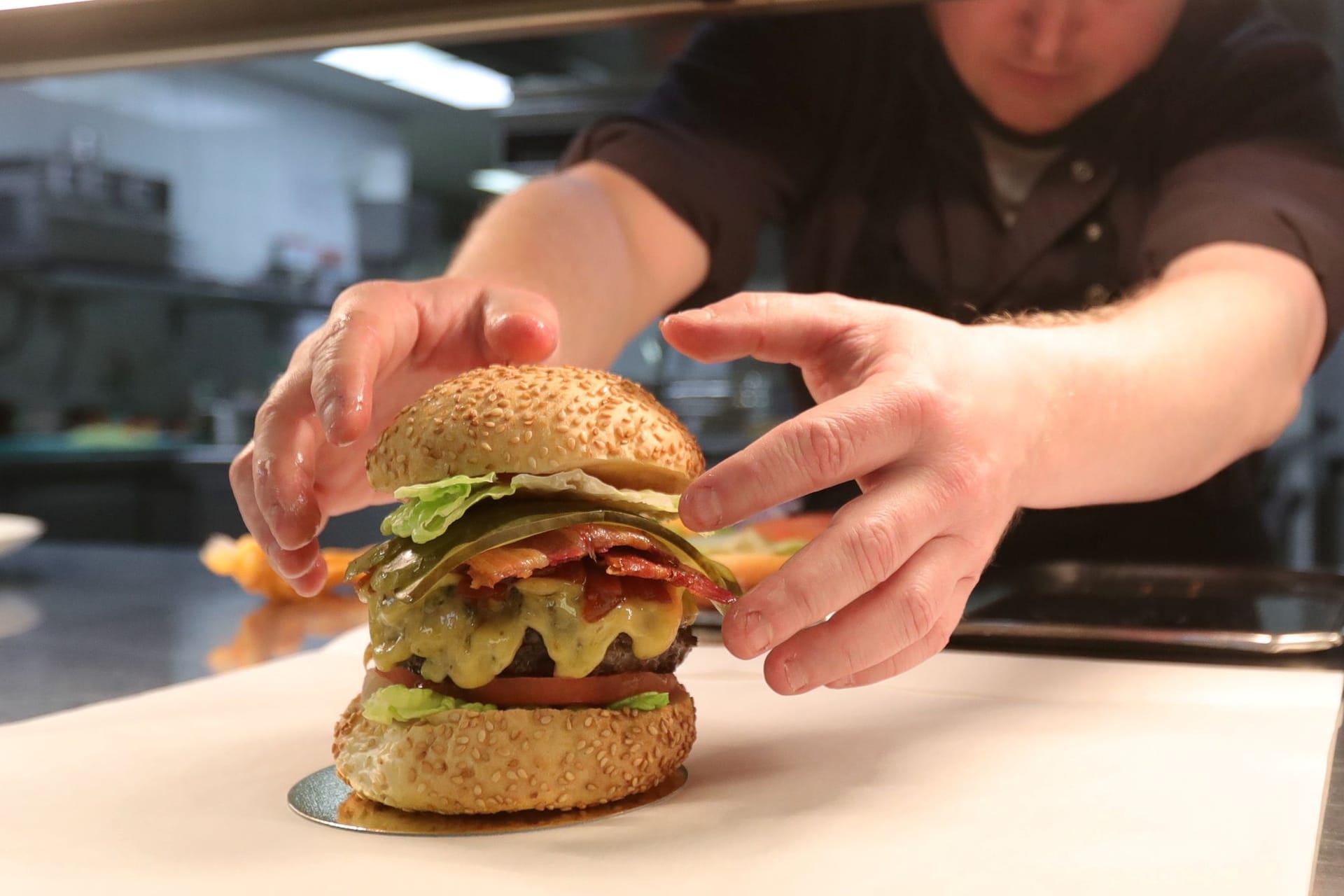 Ein Burger wird in einem Restaurant zubereitet (Symbolbild).