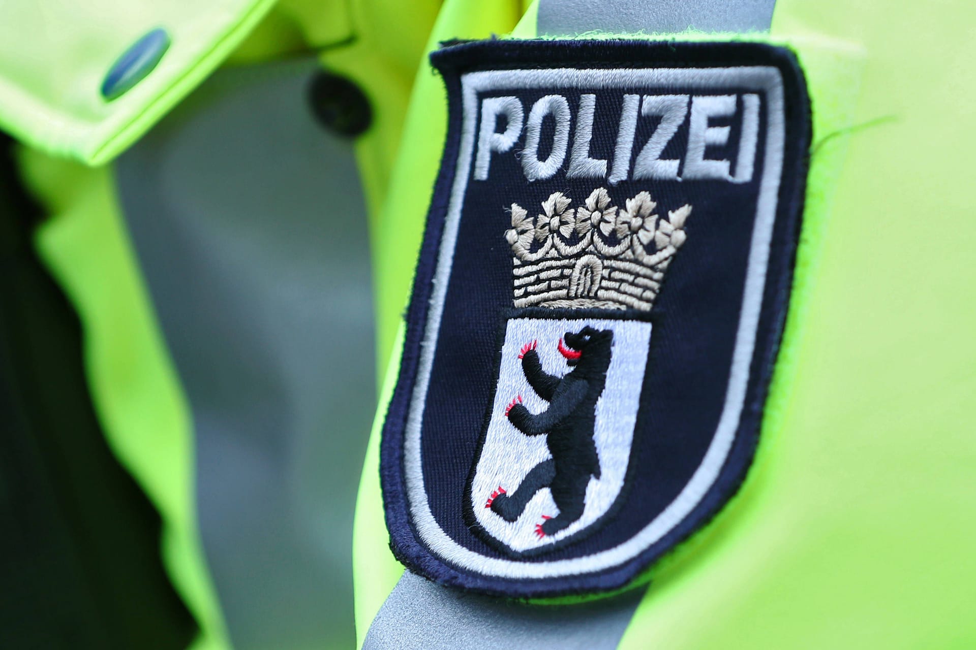 15.01.2024, Berlin, Polizeieinsatz Schriftzug in Nahaufnahme. Polizisten in gelber Leuchtjacke bei einer Verkehrskontrolle. Logo Wappen der Berliner Polizei in Nahaufnahme Berlin Deutschland