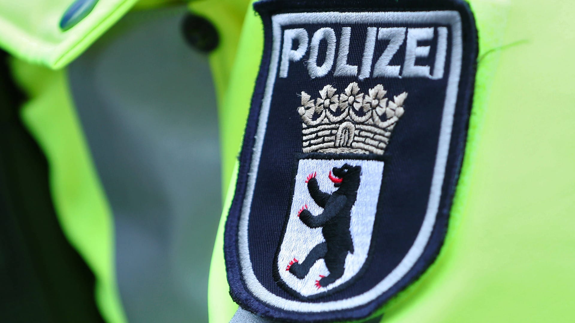 15.01.2024, Berlin, Polizeieinsatz Schriftzug in Nahaufnahme. Polizisten in gelber Leuchtjacke bei einer Verkehrskontrolle. Logo Wappen der Berliner Polizei in Nahaufnahme Berlin Deutschland