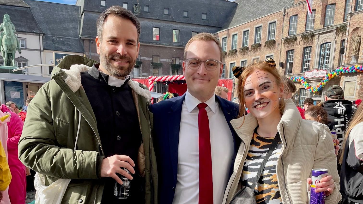 Mirco Budde (Mitte) "verkleidet" als CDU-Politiker Jens Spahn: Zusammen wird an Altweiber mit Stefan und Jessi vor dem Rathaus gefeiert.