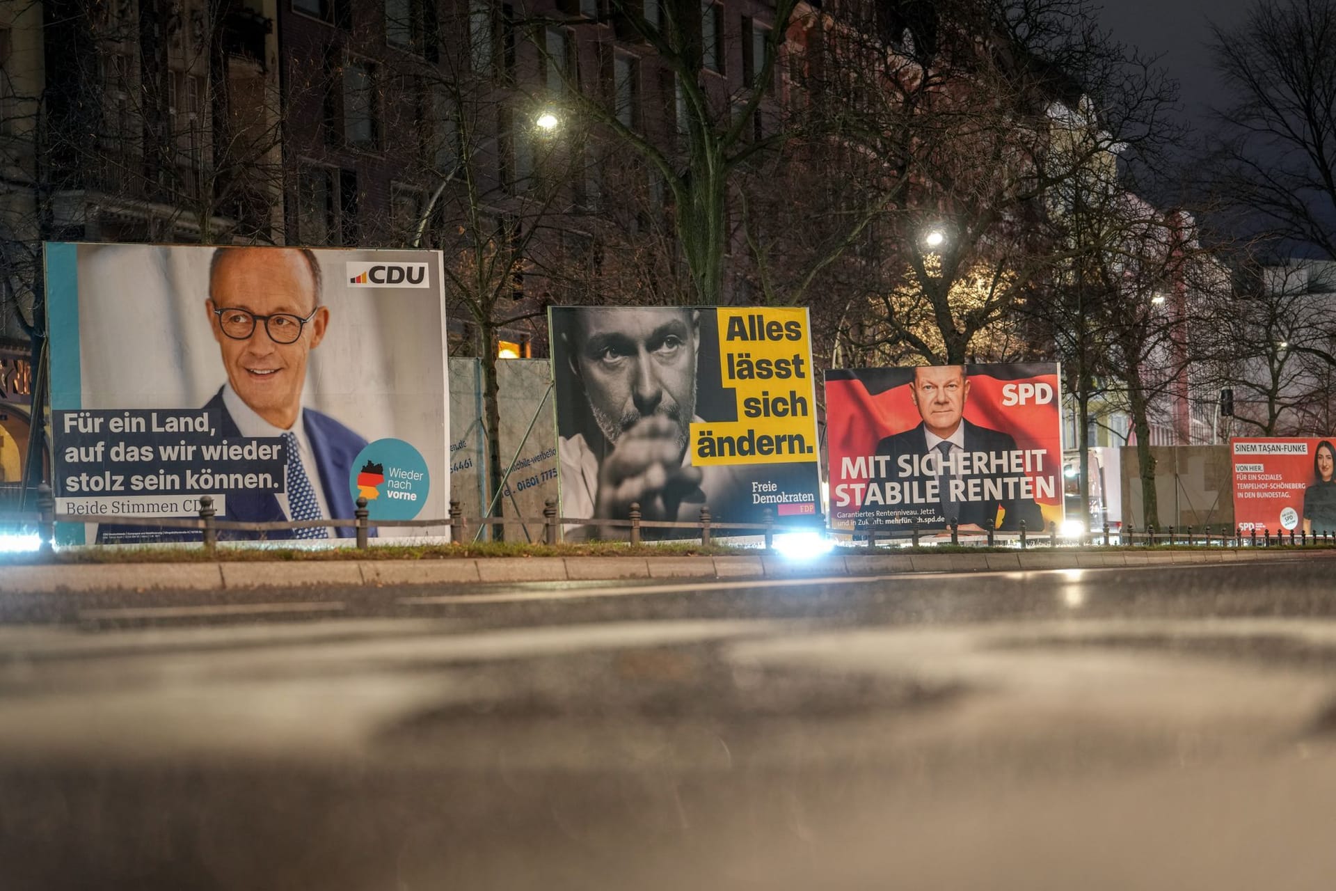 ARCHIV - 27.01.2025, Berlin: Großflächige Wahlplakate zeigen den CDU-Vorsitzenden und Kanzlerkandidaten der Unions-Bundestagsfraktion, Merz, den FDP-Vorsitzenden Lindner und den Bundeskanzler und Spitzenkandidaten der SPD, Scholz, am frühen Morgen an einer Straße in Schöneberg. In der Winterfeldtstraße sind Wahlhelfer der CDU angegriffen worden. (zu dpa: «Wahlhelfer in Berlin angegriffen») Foto: Kay Nietfeld/dpa