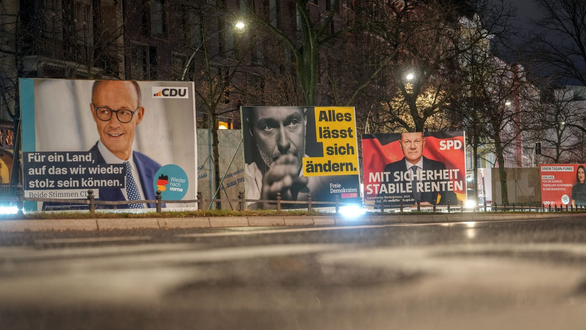 ARCHIV - 27.01.2025, Berlin: Großflächige Wahlplakate zeigen den CDU-Vorsitzenden und Kanzlerkandidaten der Unions-Bundestagsfraktion, Merz, den FDP-Vorsitzenden Lindner und den Bundeskanzler und Spitzenkandidaten der SPD, Scholz, am frühen Morgen an einer Straße in Schöneberg. In der Winterfeldtstraße sind Wahlhelfer der CDU angegriffen worden. (zu dpa: «Wahlhelfer in Berlin angegriffen») Foto: Kay Nietfeld/dpa