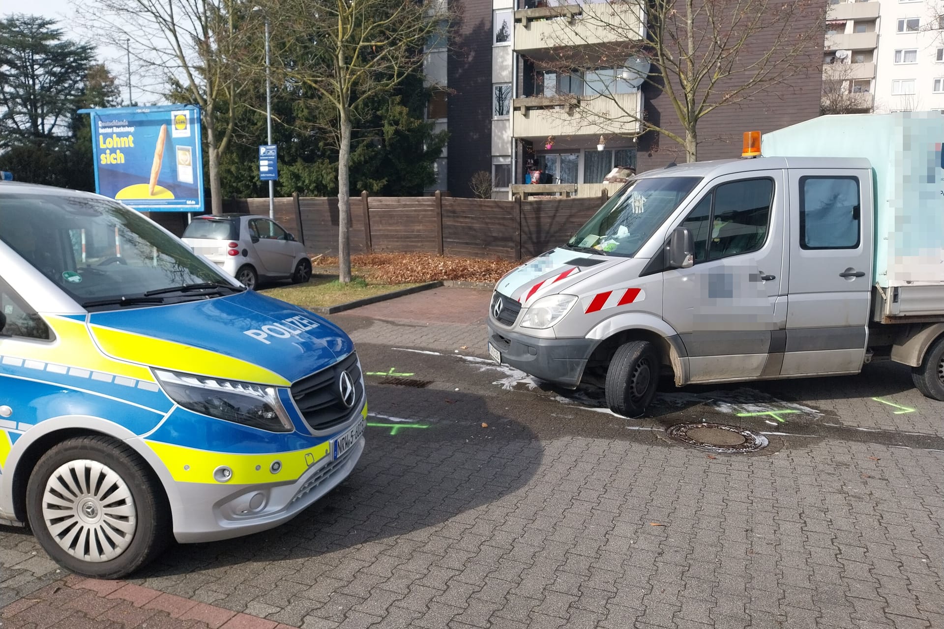 Ein Polizeiwagen beim Einsatz im Kölner Süden: Auf dem Parkplatz eines Supermarktes kam es zu einem tödlichen Unfall.