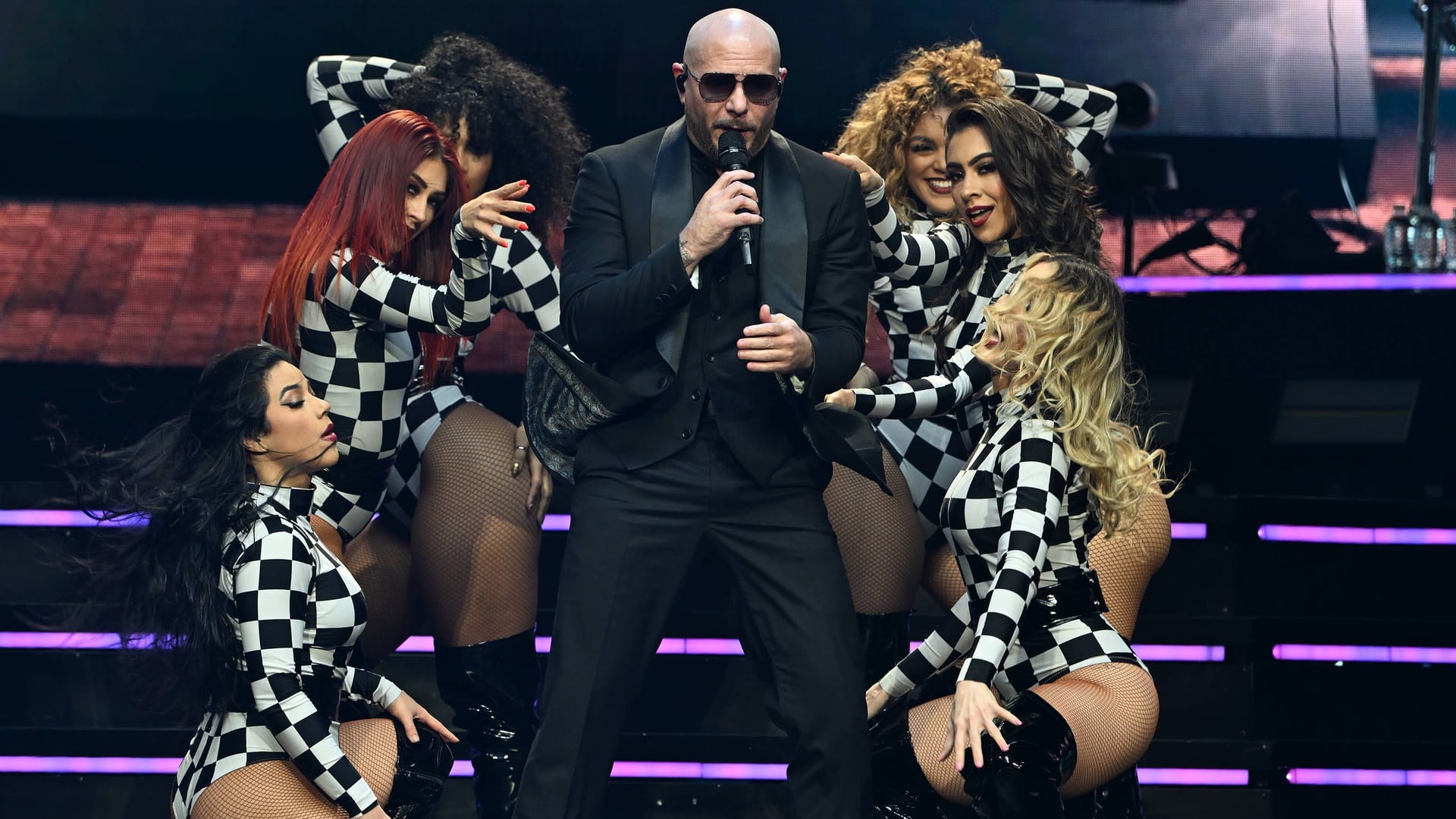 Pitbull umringt von Tänzerinnen (Archivbild): Der Musiker kommt im Sommer 2025 für ein Konzert nach Hamburg.