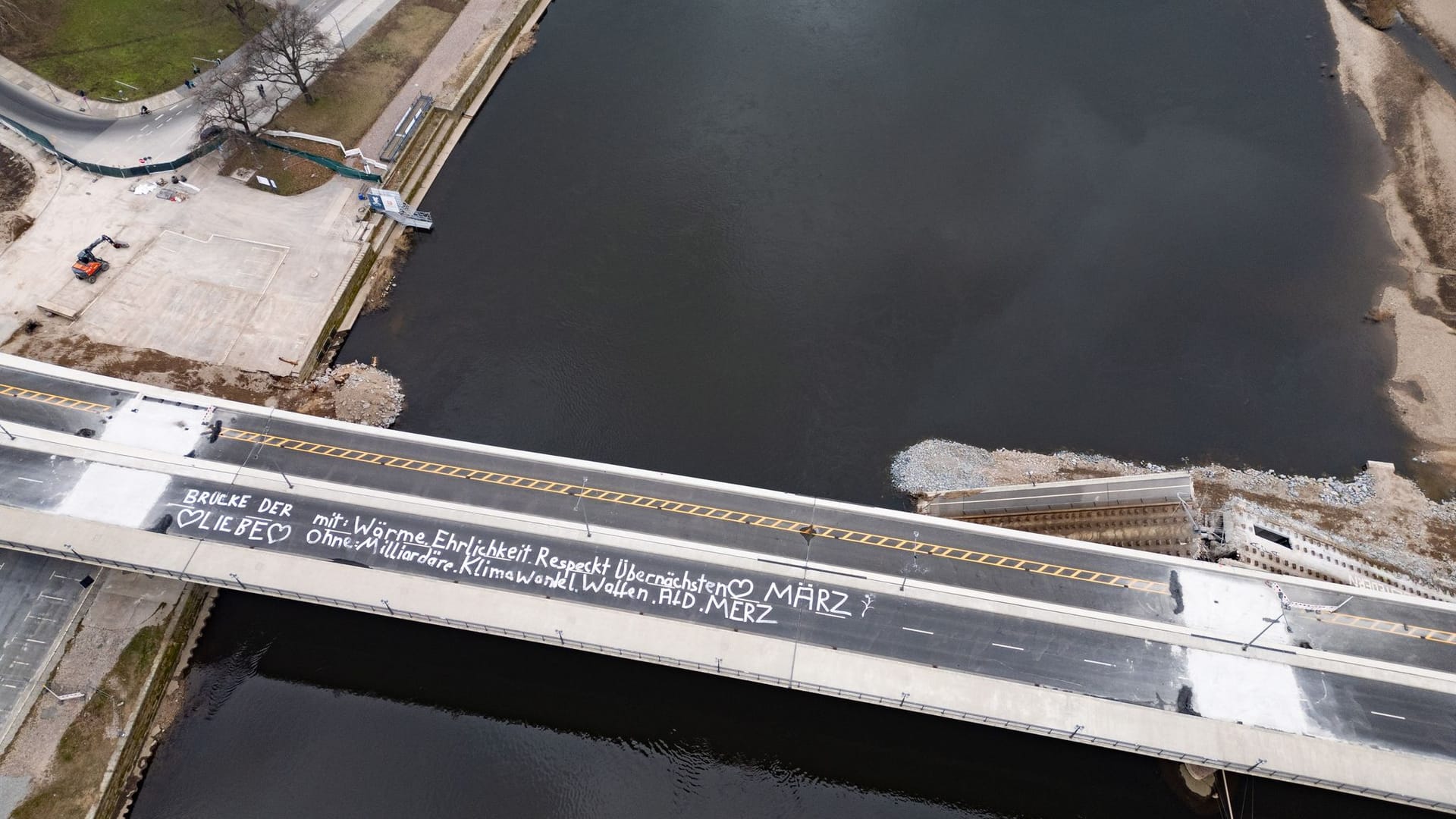 Auf dem noch erhaltenen Brückenzug der teileingestürzten Carolabrücke steht «Brücke der Liebe, mit Wärme, Ehrlichkeit, Respekt, Übernächstenliebe, März. Ohne Milliardäre, Klimawandel, Waffen, AfD, Merz» geschrieben (Aufnahme mit einer Drohne).