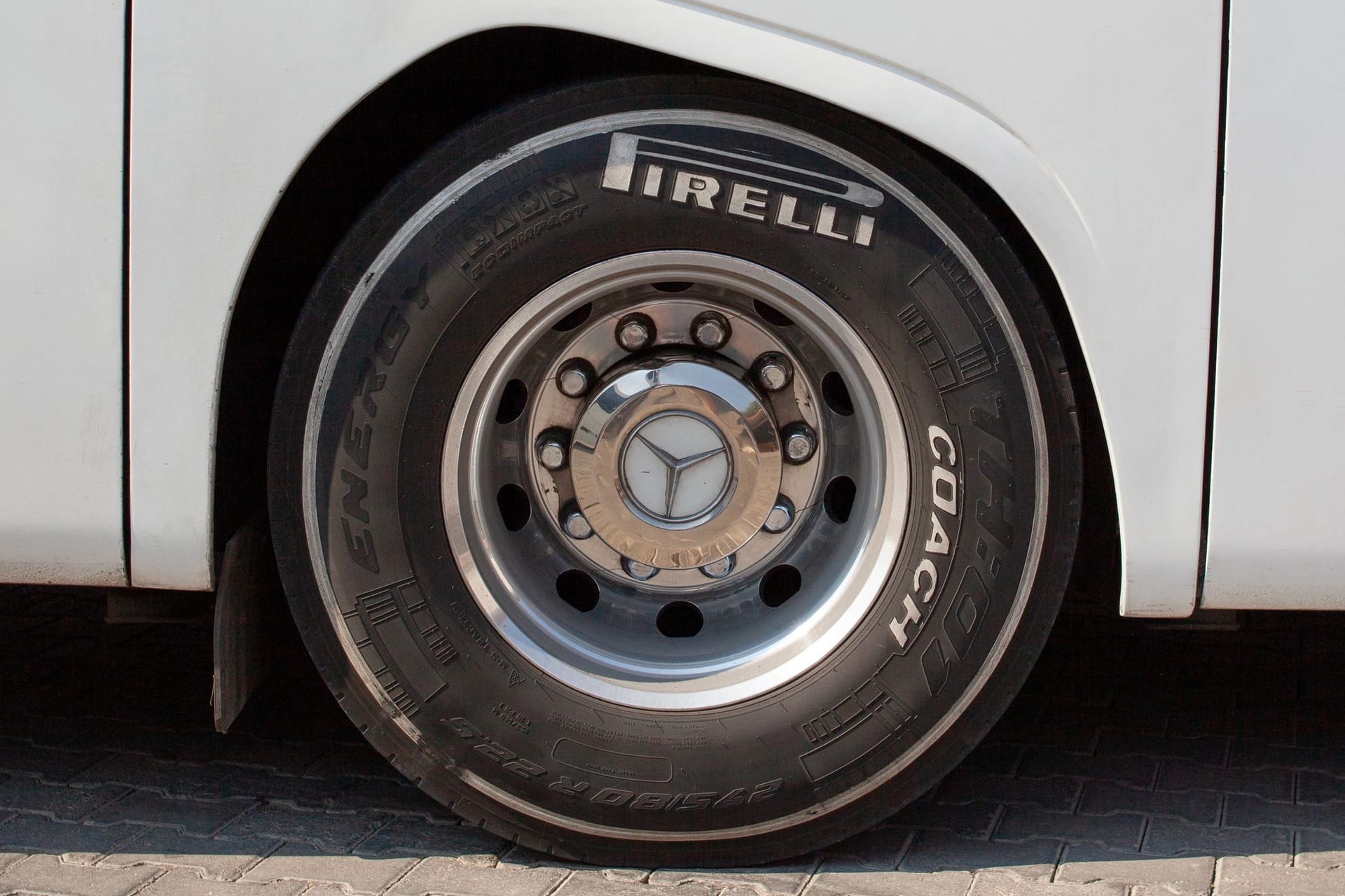 Huge bus wheel with a shiny disc. White bus wheel arch. Pirelli tire