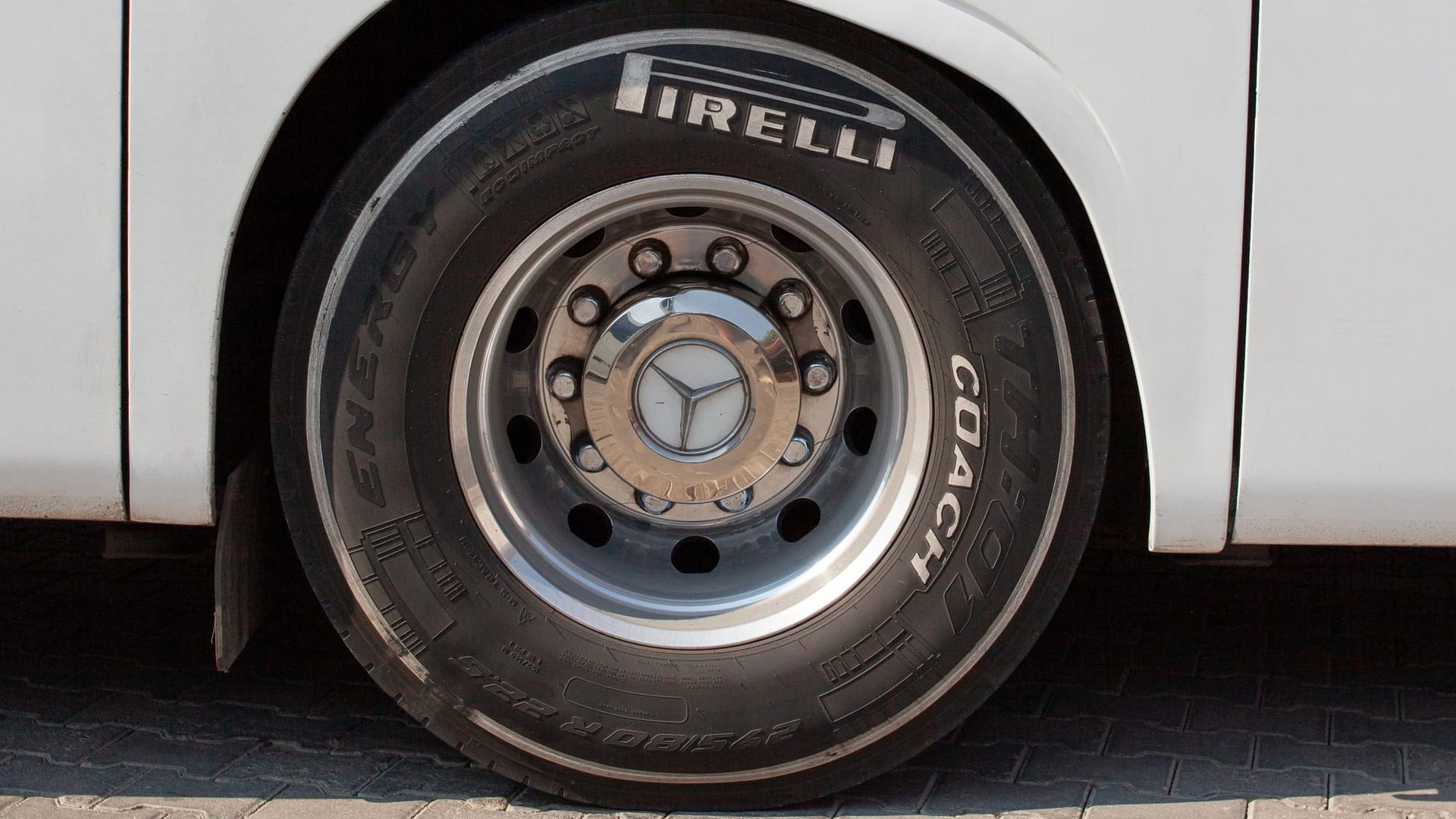 Huge bus wheel with a shiny disc. White bus wheel arch. Pirelli tire