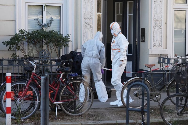 Mitarbeiterinnen der Spurensicherung vor einem Mehrfamilienhaus: In einer Wohnung wurde eine tote Frau gefunden.