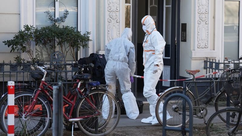 Mitarbeiterinnen der Spurensicherung vor einem Mehrfamilienhaus: In einer Wohnung wurde eine tote Frau gefunden.