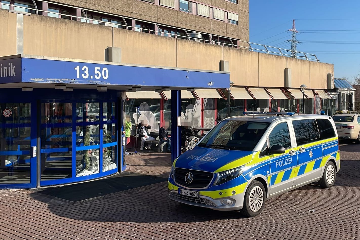 Der Eingang der Düsseldorfer Uniklinik: Nach Schüssen auf einen Messerangreifer stehen mehrere Streifenwagen vor dem Gebäude.