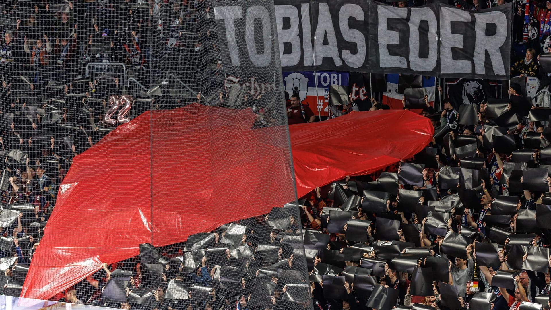 Abschied von Tobias Eder: Eisbären-Fans halten ein großes Herz zu Ehren des verstorbenen Spielers in die Höhe.