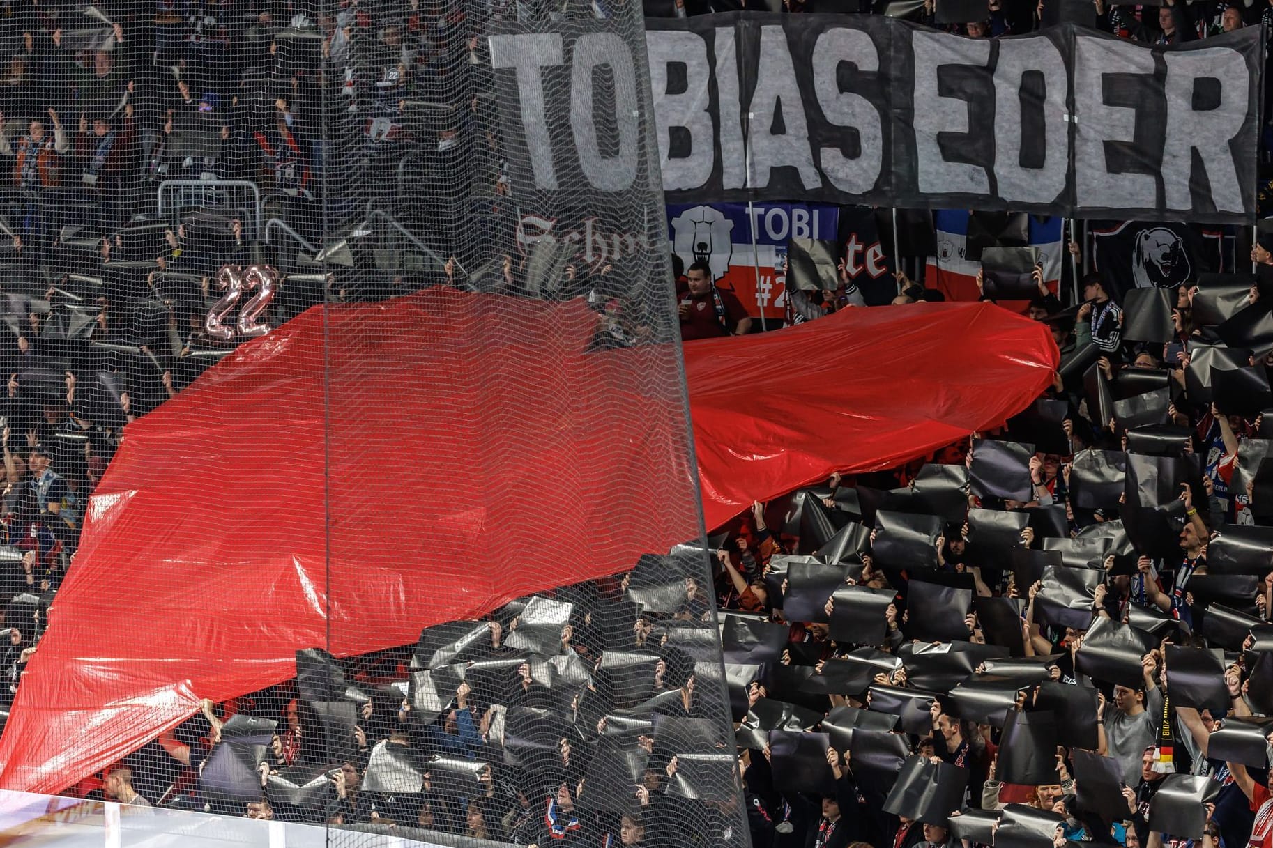 Abschied von Tobias Eder: Eisbären-Fans halten ein großes Herz zu Ehren des verstorbenen Spielers in die Höhe.