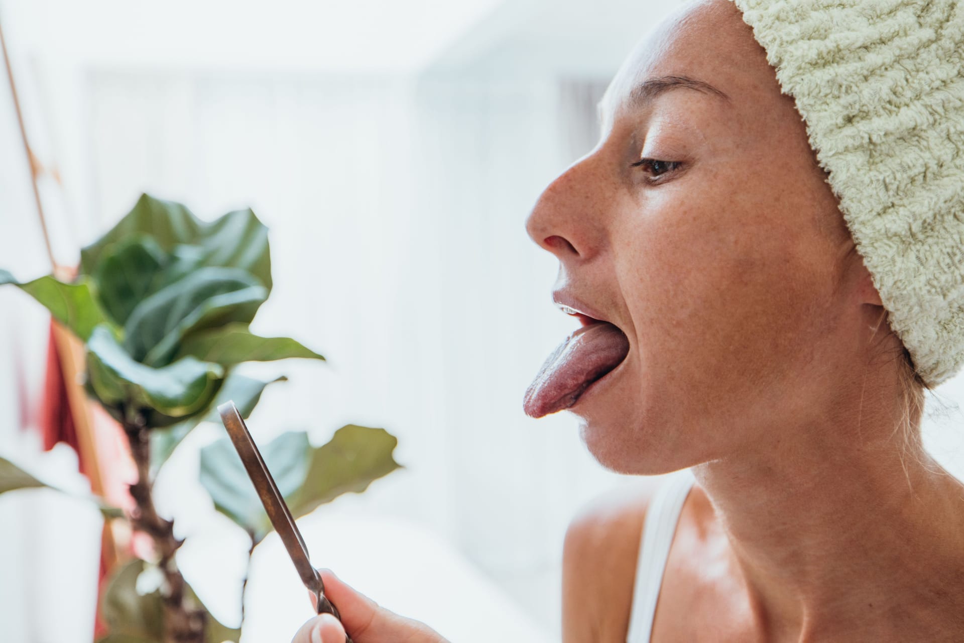 Frau schaut sich im Spiegel ihre Zunge an (Symbolbild): Anhaltendes Lippen- und Zungenbrennen kann sehr belastend sein.