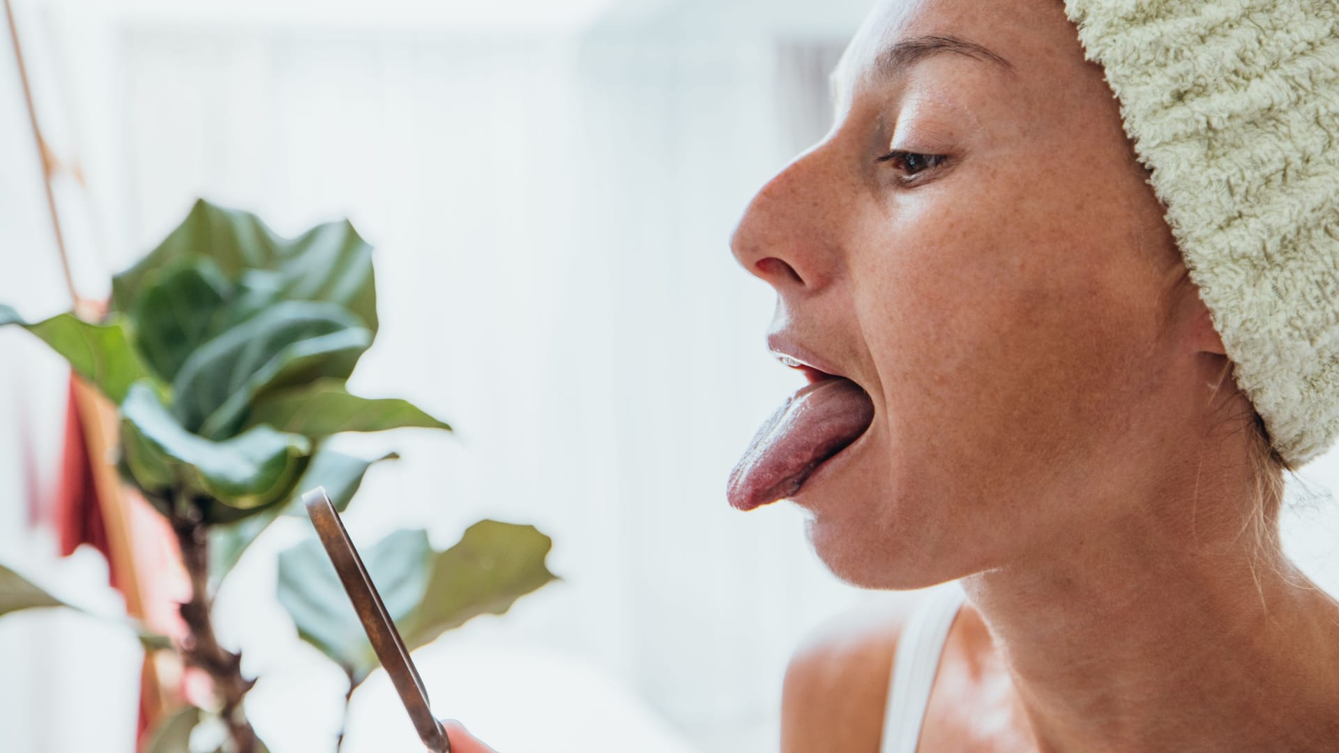 Frau schaut sich im Spiegel ihre Zunge an (Symbolbild): Anhaltendes Lippen- und Zungenbrennen kann sehr belastend sein.