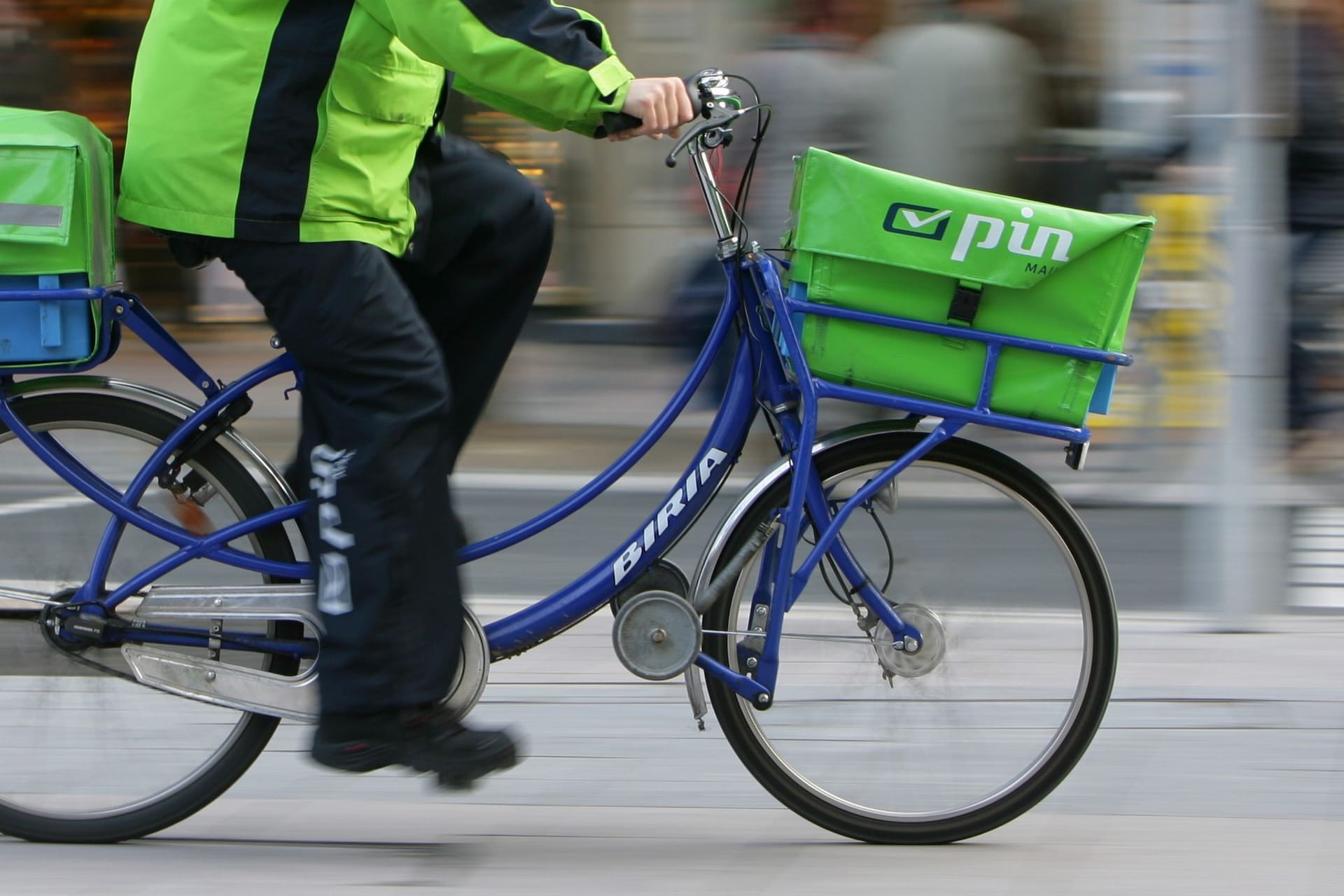 Briefzusteller des Dienstleisters Pin Mail auf einem Fahrrad