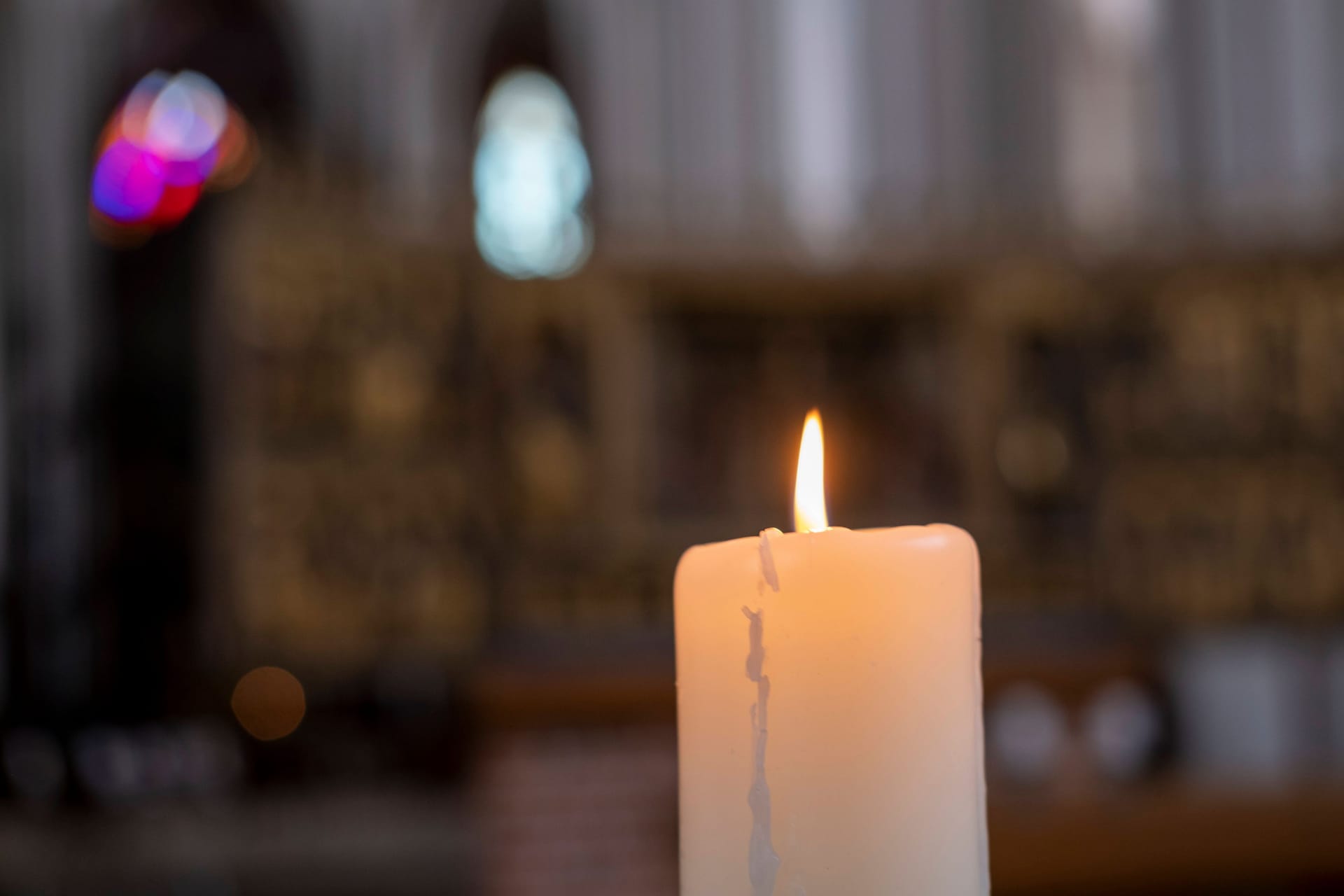 Eine Kerze brennt in einer Kirche (Symbolbild).