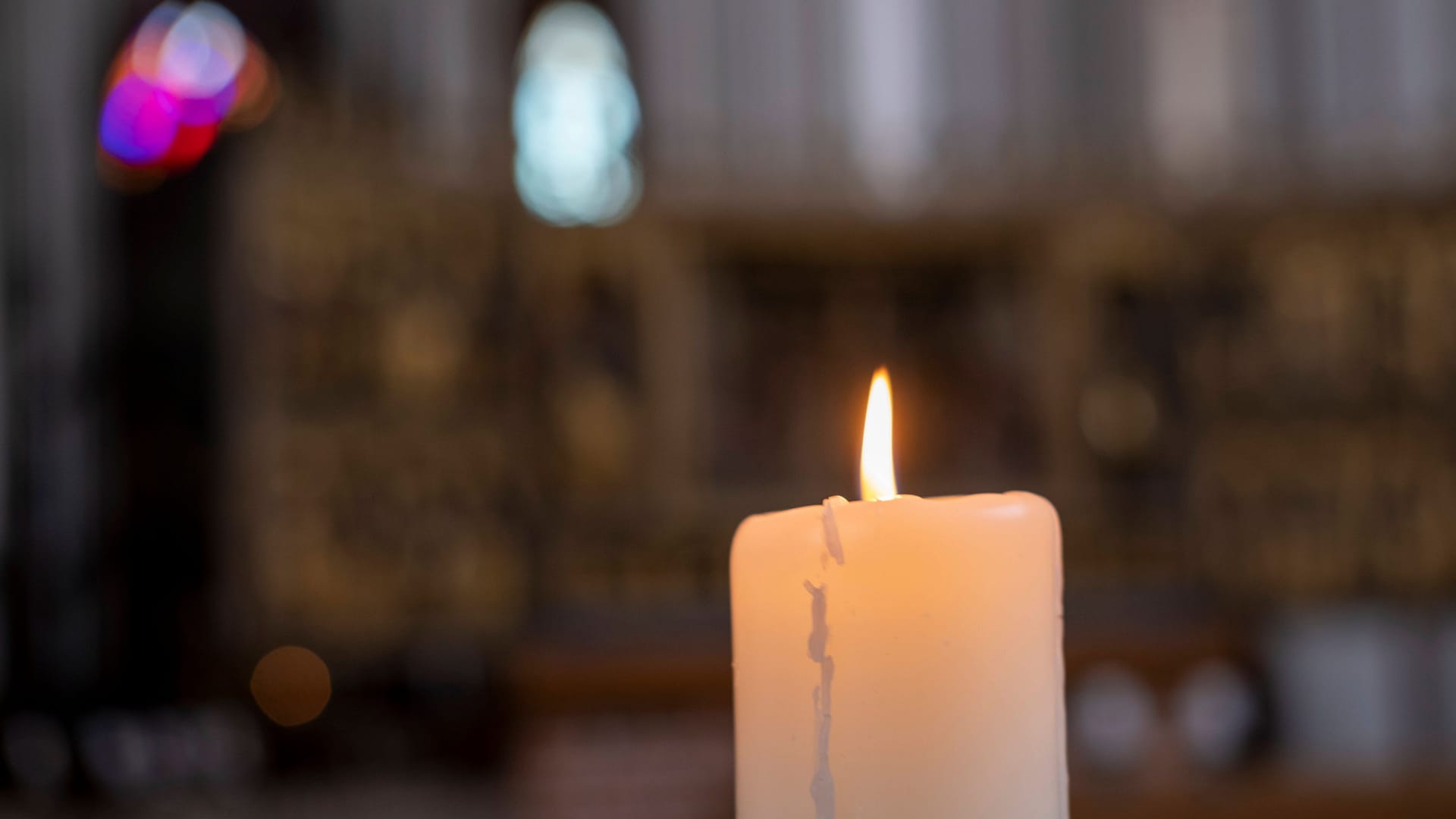 Eine Kerze brennt in einer Kirche (Symbolbild).