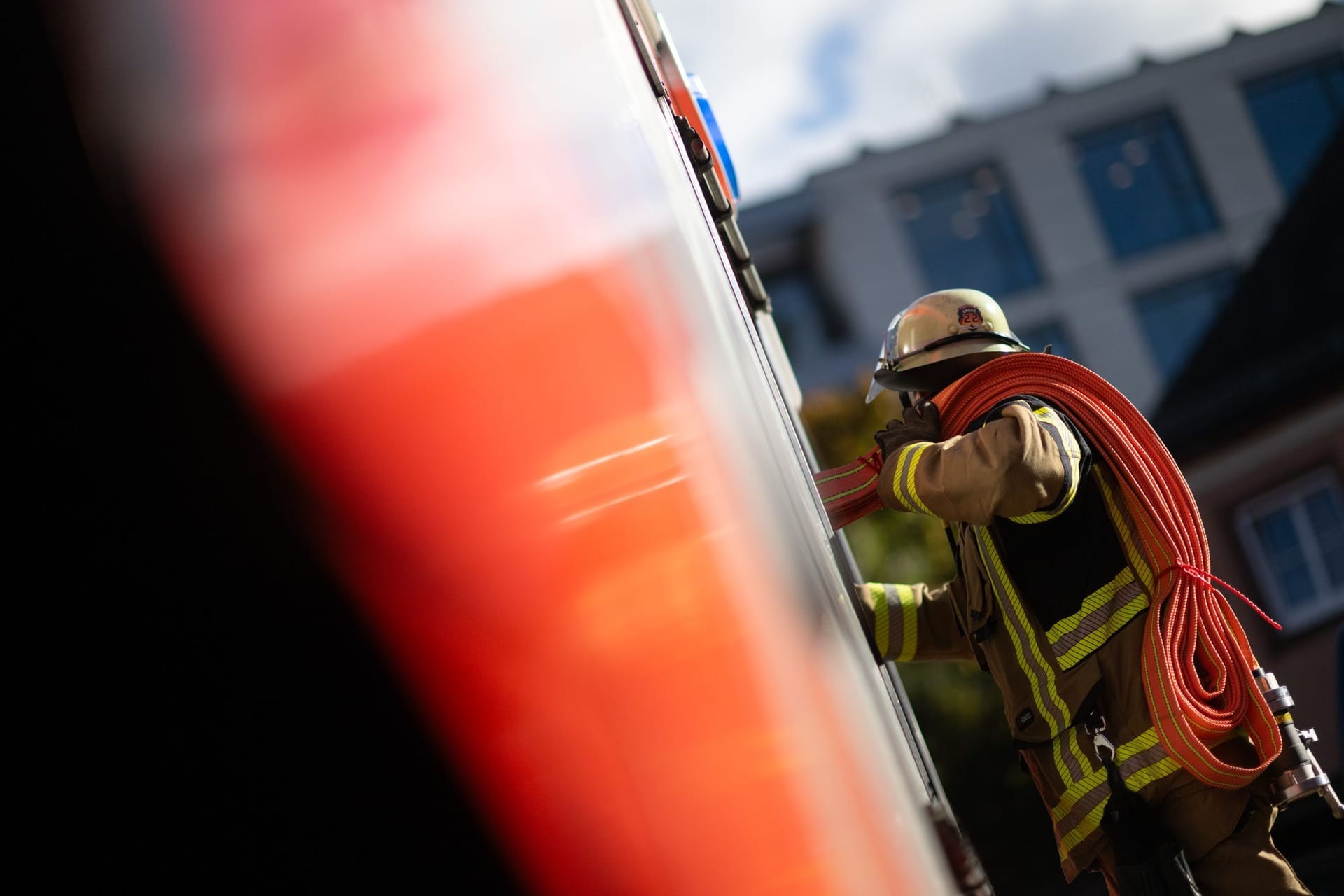 Ein Feuerwehrmann nimmt einen Schlauch aus einem Einsatzfahrzeug