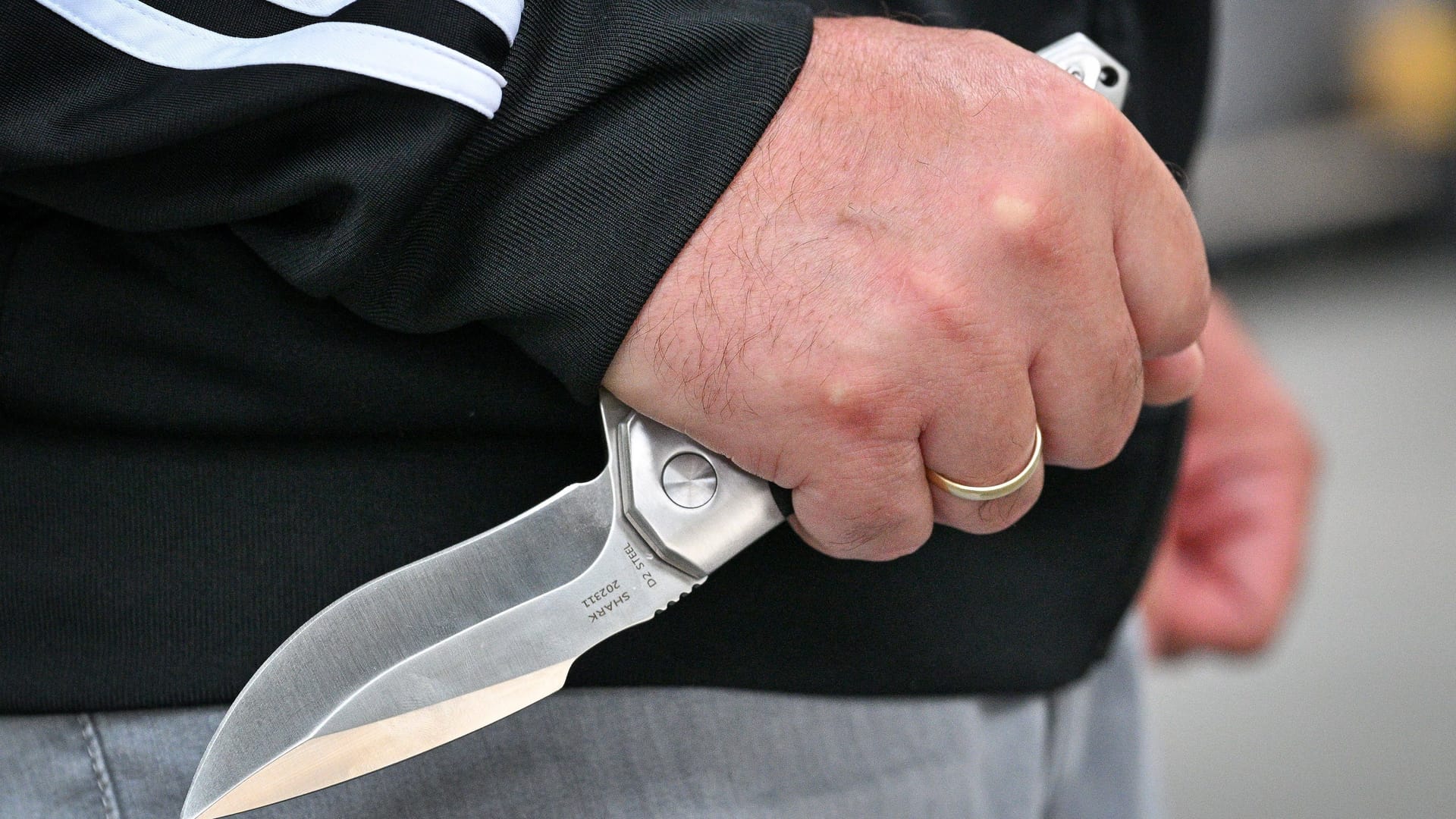 Ein Mann hält ein Messer in der Hand (Symbolbild): Die Hintergründe der Tat sind noch völlig unklar.