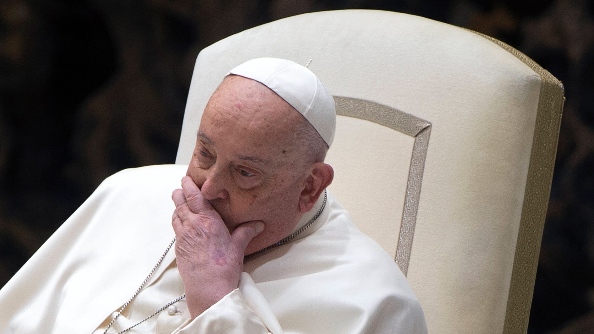 Papst sitzt im weißen Sessel.