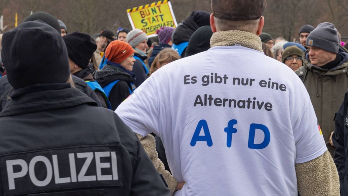 Polizisten neben Mann mit AfD-Shirt (Symbolbild): In Berlin kam es zu einer Auseinandersetzung.