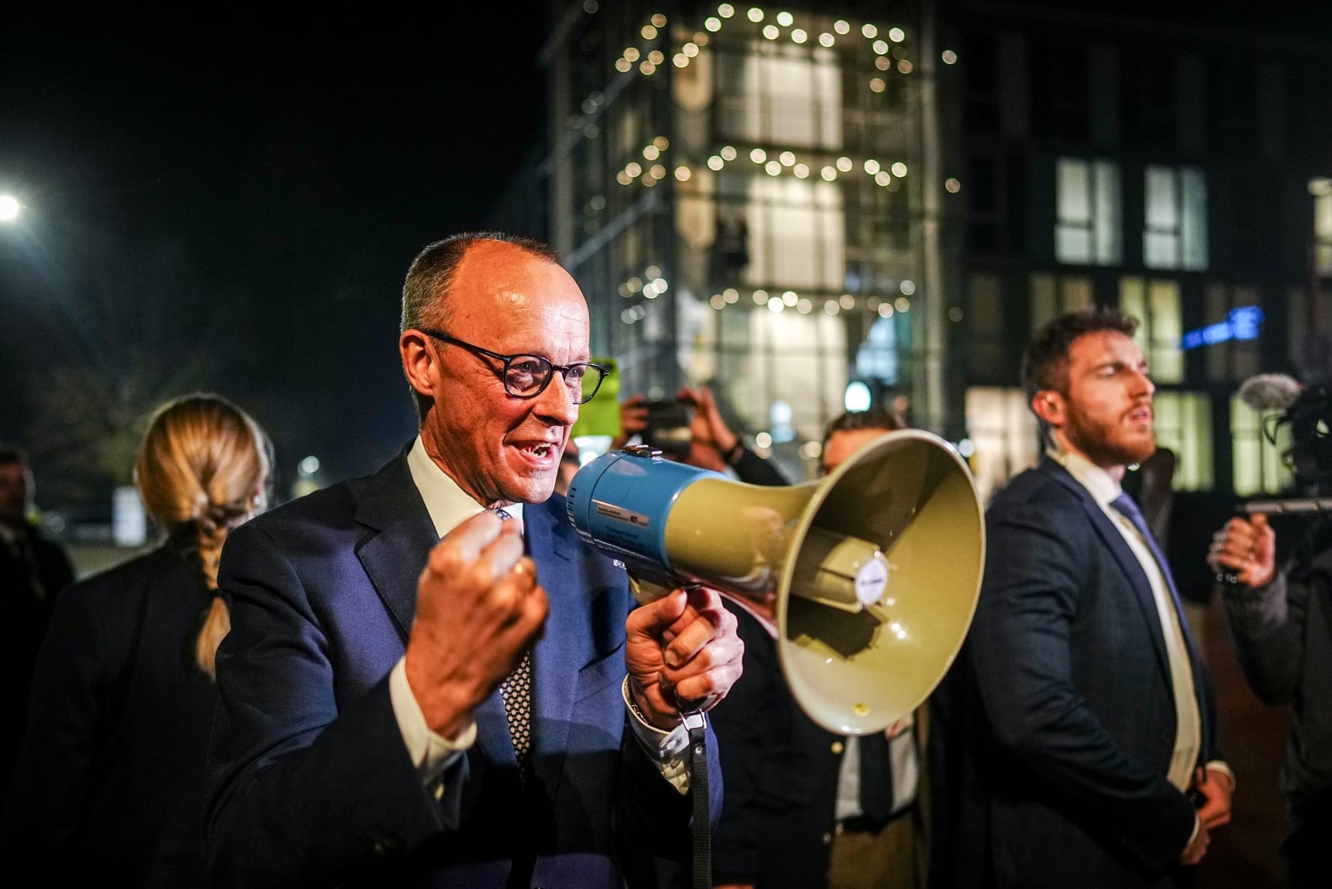 Friedrich Merz, Unions-Kanzlerkandidat, spricht durch ein Megaphon bei seiner Ankunft beim TV-Duell von ARD und ZDF am Studio zu seinen Anhängern.