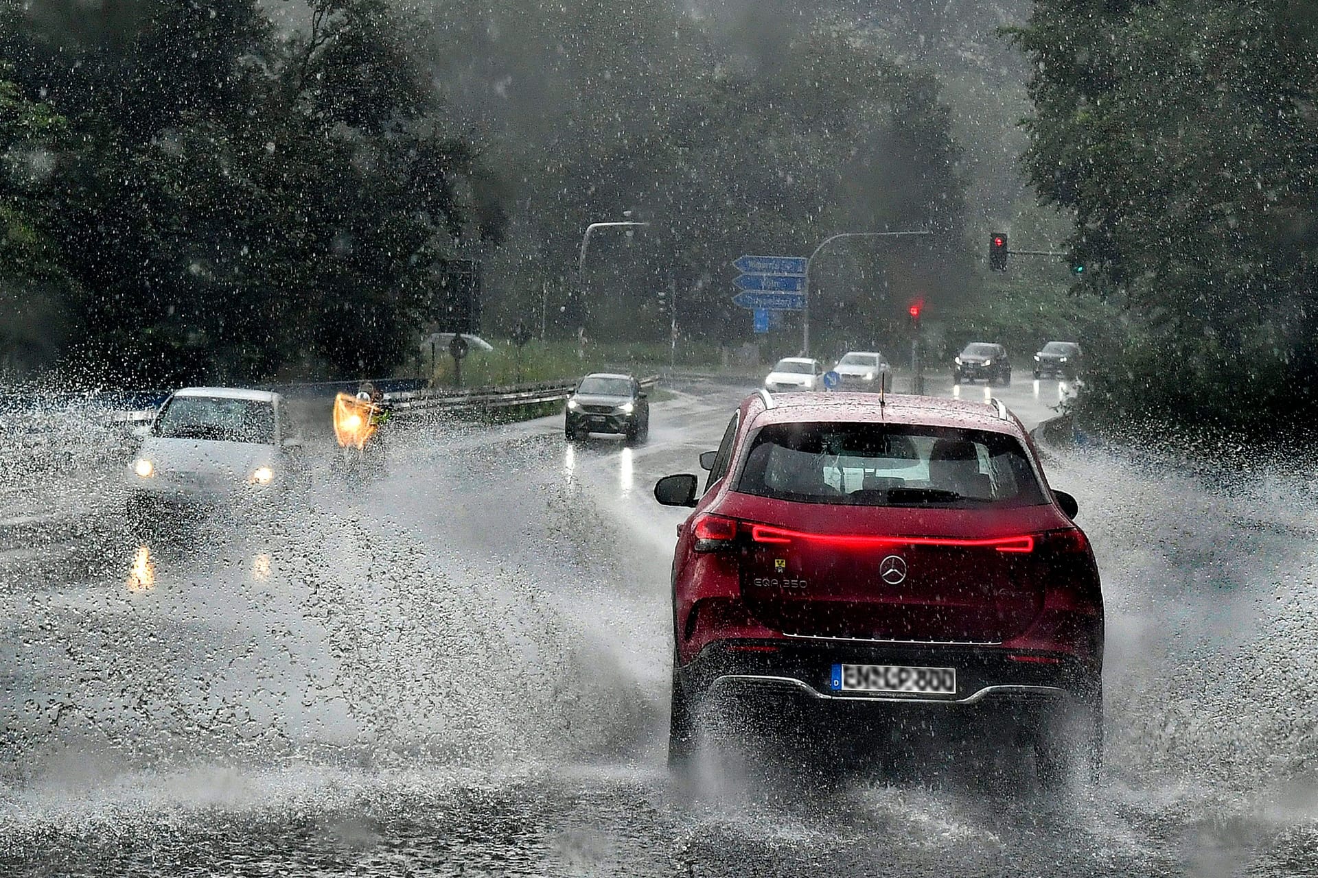 Ein Auto fährt durch eine Starkregenfront (Archivbild): Ein Atlantiktief erreicht Köln zu den Karnevalstagen und bringt Unwetter zu Weiberfastnacht.