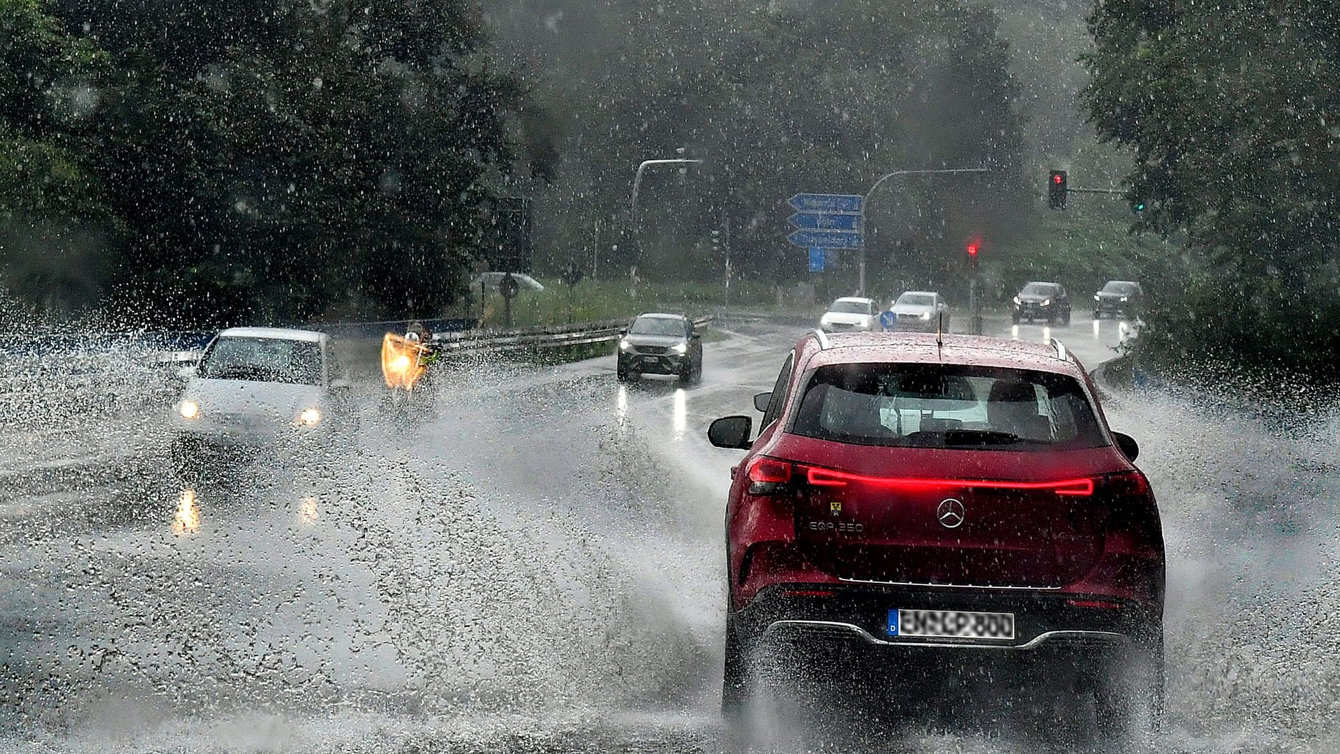 Ein Auto fährt durch eine Starkregenfront (Archivbild): Ein Atlantiktief erreicht Köln zu den Karnevalstagen und bringt Unwetter zu Weiberfastnacht.