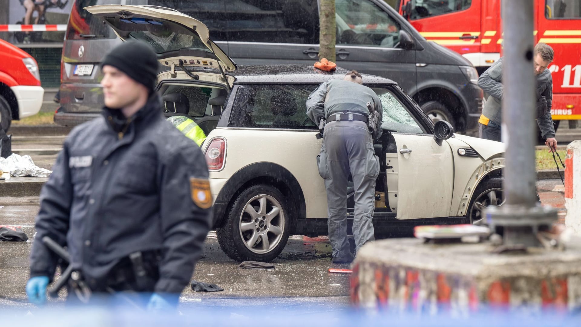 Polizisten sichern das Auto des Täters.