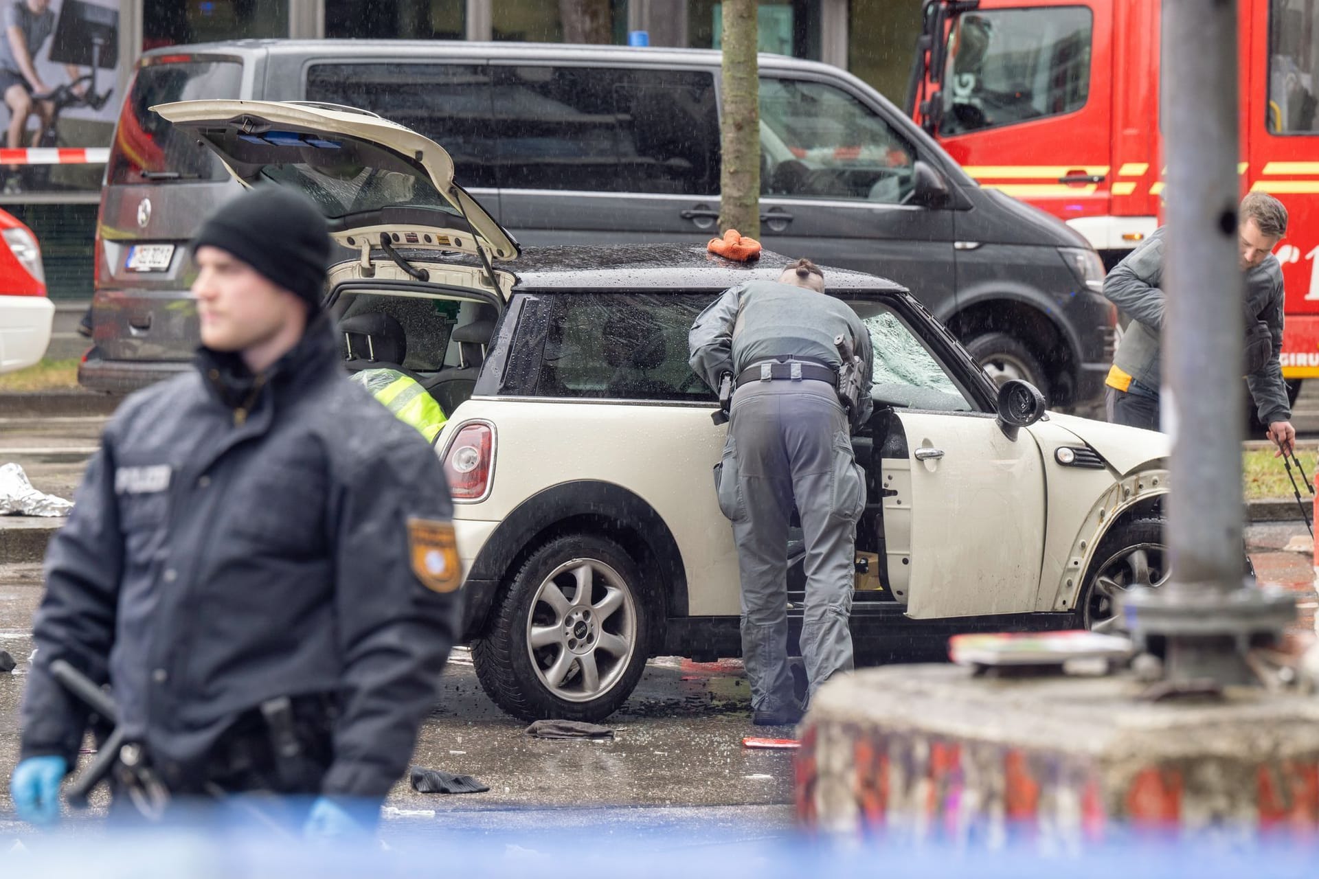 Polizisten sichern das Auto des Täters.