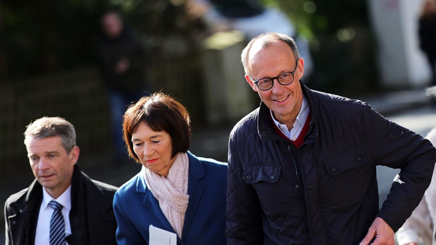 Friedrich Merz (CDU, rechts), Parteivorsitzender und Kanzlerkandidat, und seine Frau Charlotte Merz (Mitte) kommen zur Stimmabgabe ins Wahllokal.