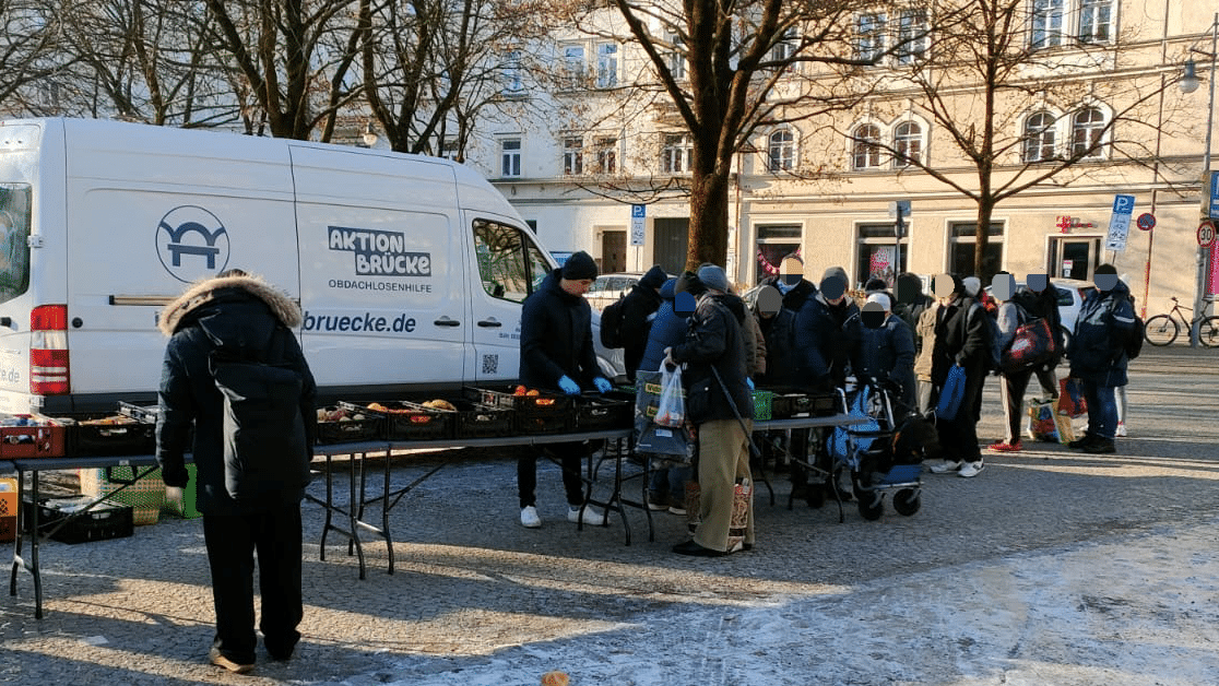 Bei der Lebensmittelausgabe müssen sich die Menschen in einer Schlange anstellen und ihren Ausweis vorzeigen.