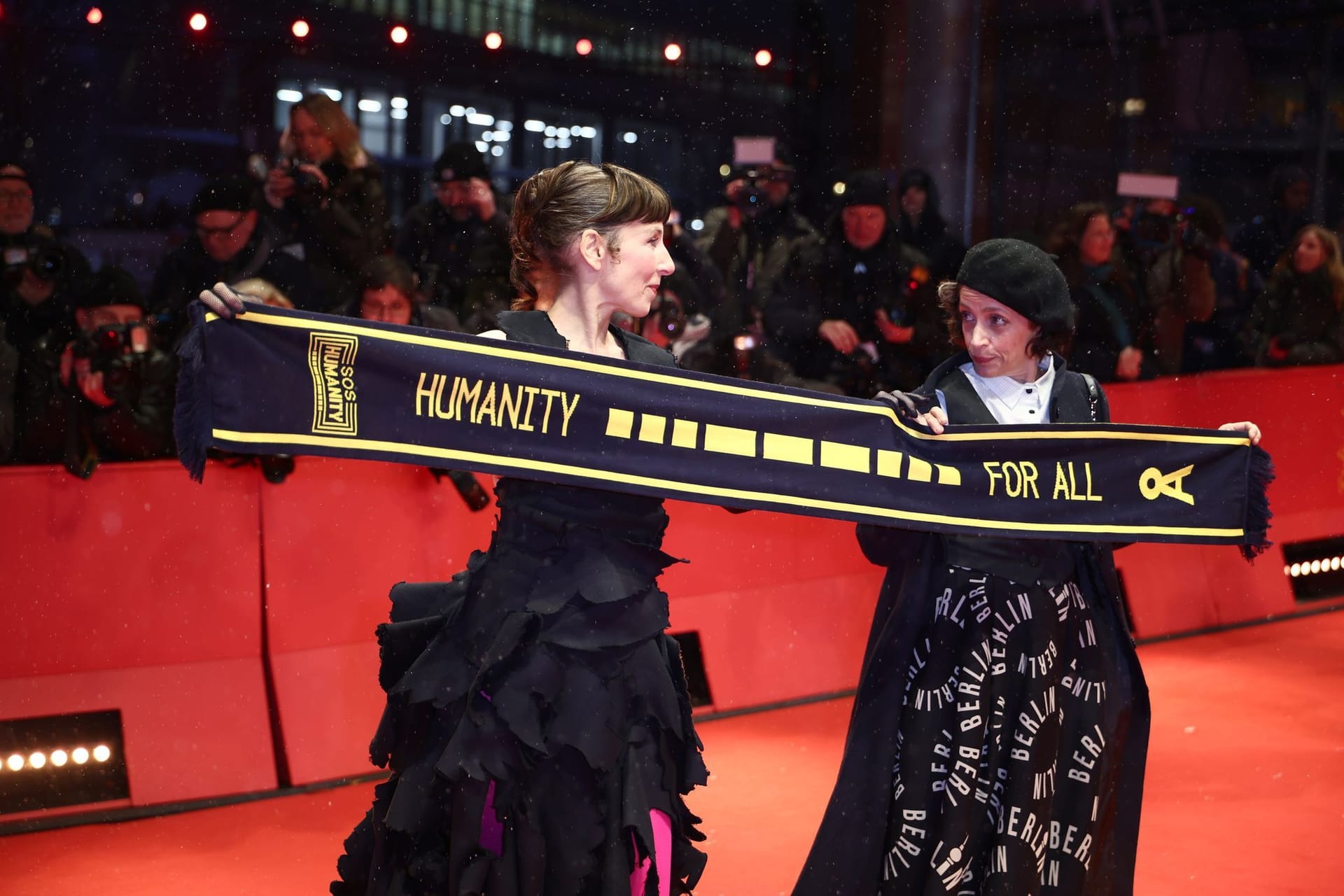 Die Schauspielerinnen Meret Becker und Anna Thalbach hielten am Eröffnungsabend der Berlinale einen Schal mit der Aufschrift "Humanity for all" von SOS Humanity hoch.