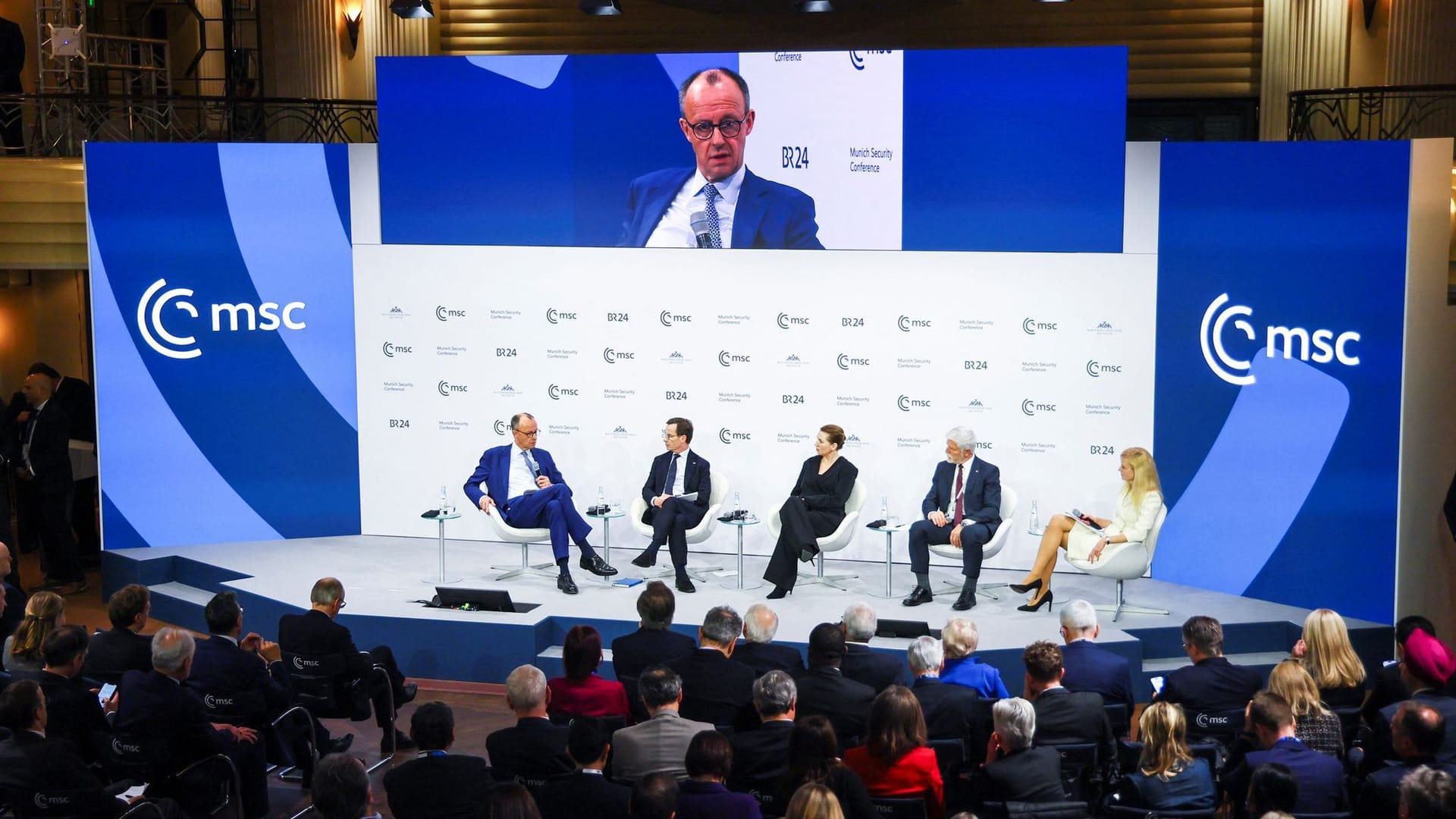 In der Podiumsdiskussion mit Merz bei der Sicherheitskonferenz geht es um die künftige Stärkung der Ukraine.