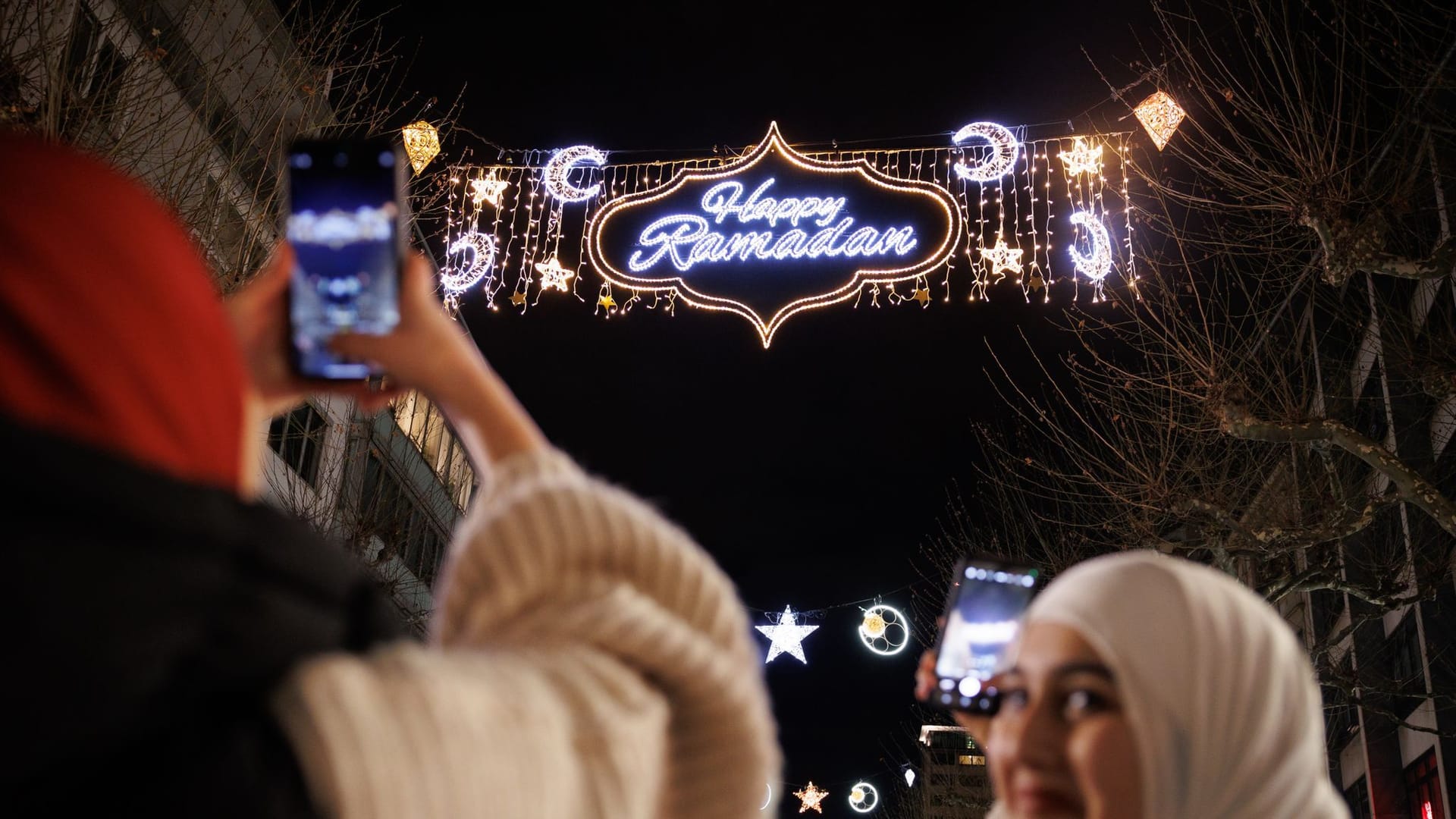 Passantinnen fotografieren mit ihren Handys die «Happy Ramadan» Beleuchtung in der Freßgass von Frankfurt am Main. Die Beleuchtung mit dem Schriftzug «Happy Ramadan» wurde 2023 von der Stadtverordnetenversammlung beschlossen.