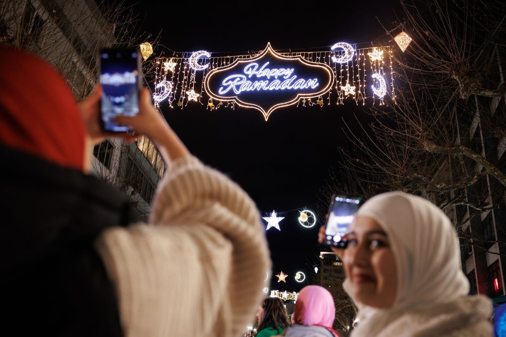 Passantinnen fotografieren mit ihren Handys die "Happy Ramadan"-Beleuchtung in der Frankfurt (Symbolfoto): Ähnliches wünschen sich die Grünen für Berlin.