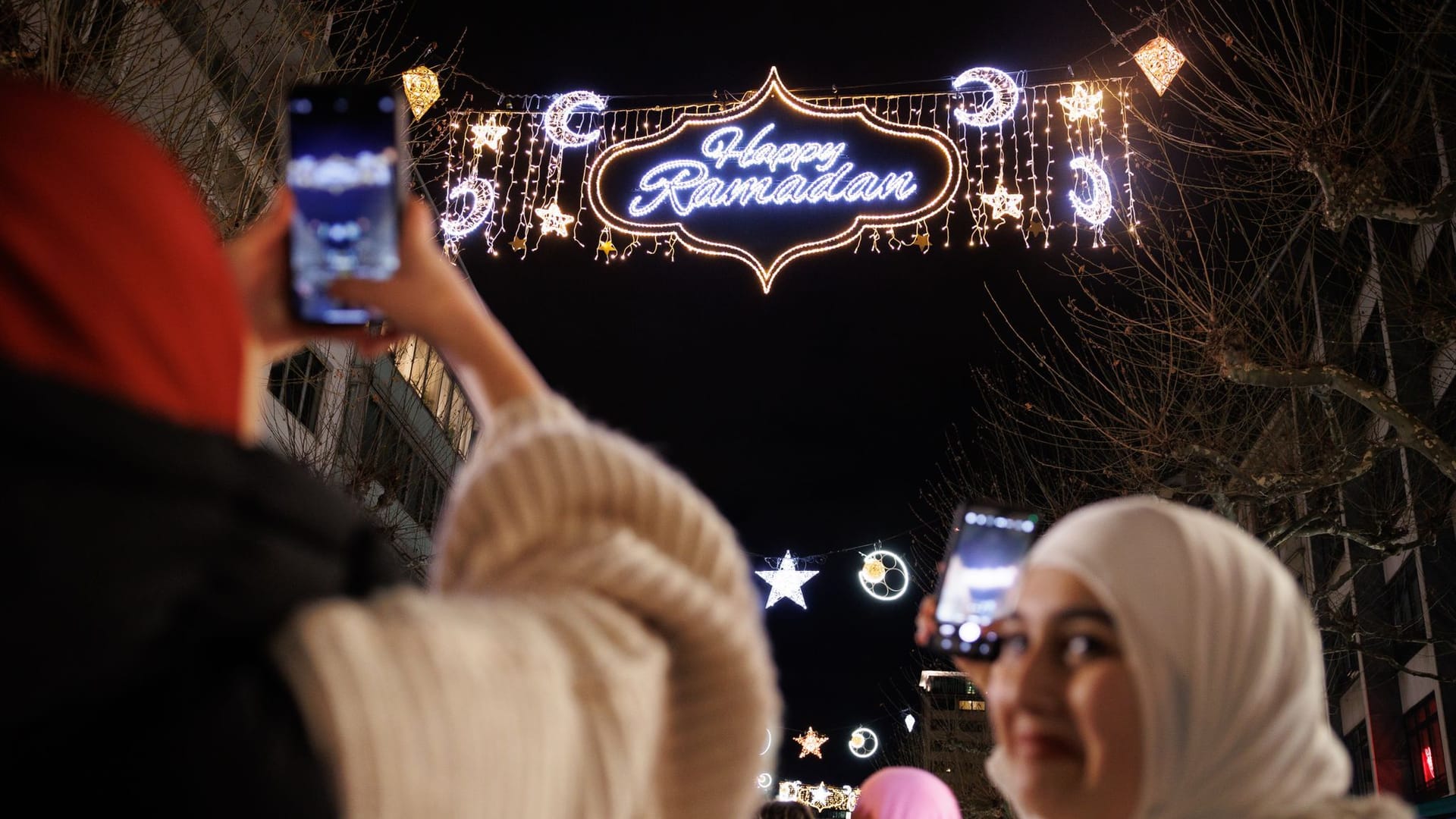Passantinnen fotografieren mit ihren Handys die "Happy Ramadan"-Beleuchtung in der Frankfurt (Symbolfoto): Ähnliches wünschen sich die Grünen für Berlin. Passantinnen fotografieren mit ihren Handys die "Happy Ramadan"-Beleuchtung in der Frankfurt (Symbolfoto): Ähnliches wünschen sich die Grünen für Berlin.