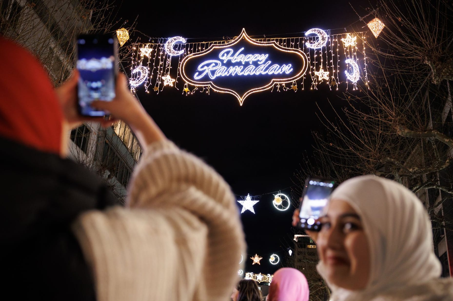 Passantinnen fotografieren mit ihren Handys die "Happy Ramadan"-Beleuchtung in der Frankfurt (Symbolfoto): Ähnliches wünschen sich die Grünen für Berlin.