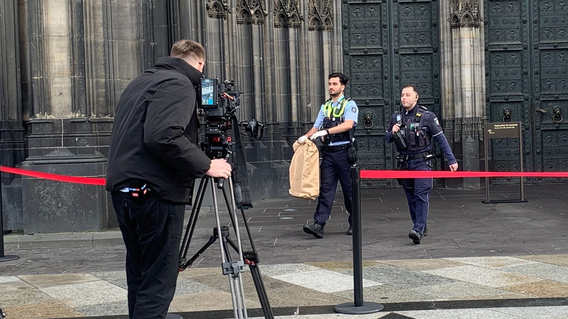 Der Koffer am Kölner Dom wird von der Polizei abtransportiert. Er stellte sich als leer heraus.