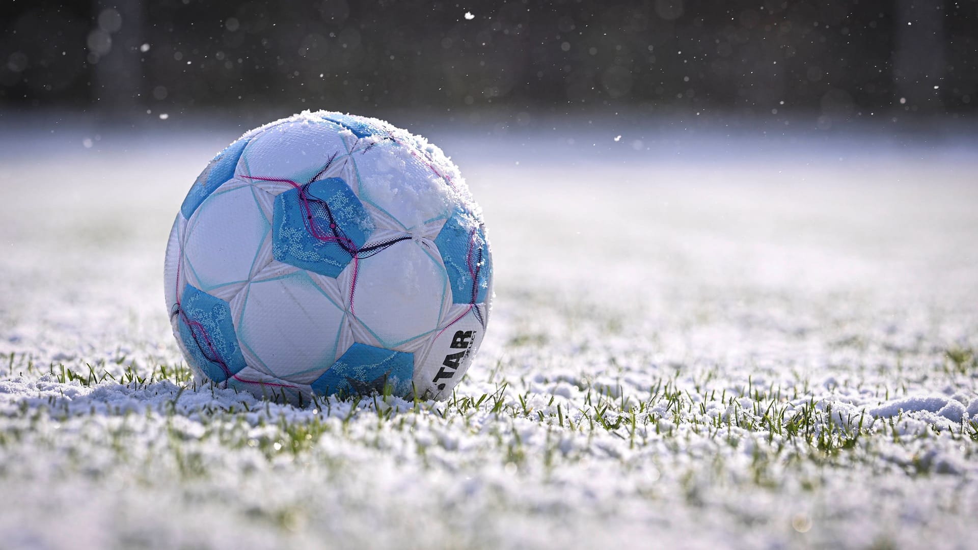 Ein Fußball auf schneebedecktem Rasen (Archivbild): In Berlin finden im Amateurbereich keine Spiele statt.