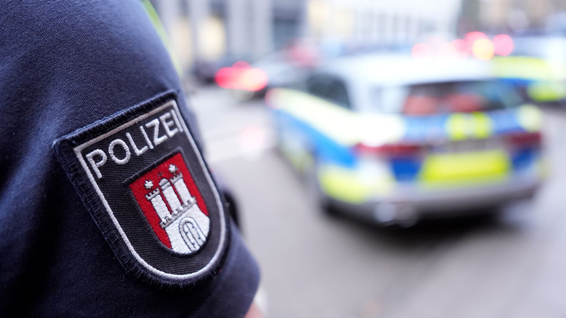 Ein Polizist steht vor einem Einsatzfahrzeug (Archivbild): Am Sonnabend überprüfte die Behörde Teilnehmer einer Veranstaltung in Hamburg-Bergedorf.