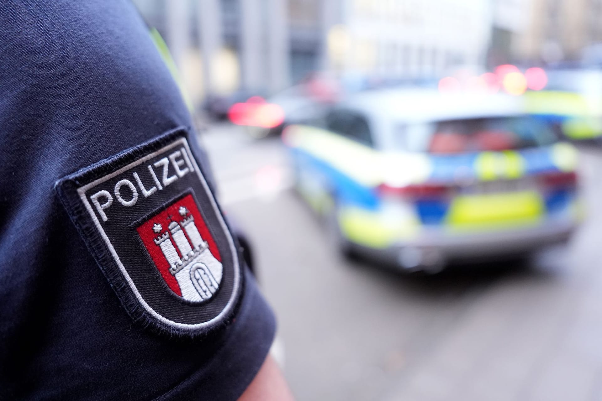 Ein Polizist steht vor einem Einsatzfahrzeug (Archivbild): Am Sonnabend überprüfte die Behörde Teilnehmer einer Veranstaltung in Hamburg-Bergedorf.