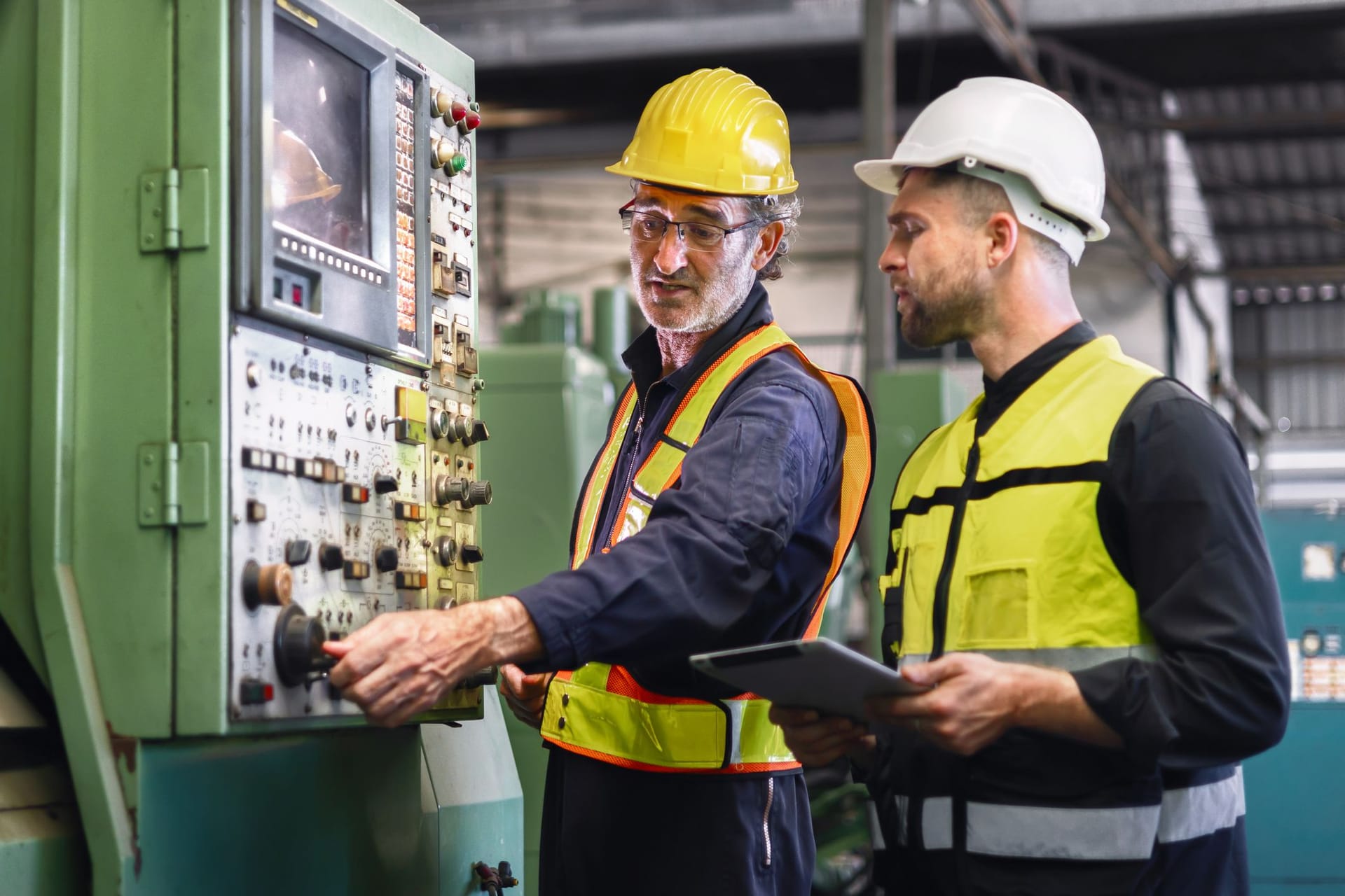 Arbeiter kontrollieren ein Steuergerät in einer Fabrik