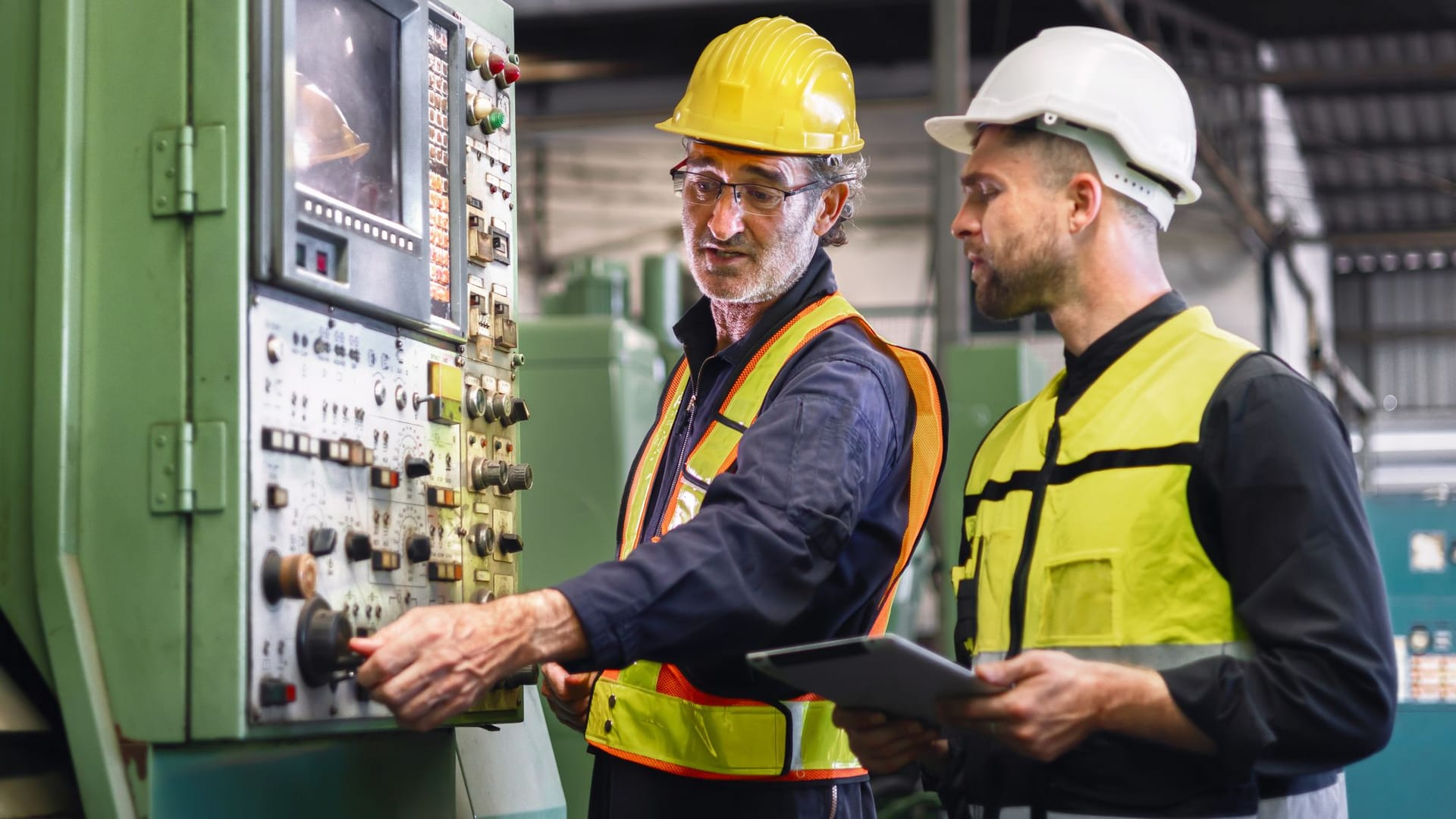 Arbeiter kontrollieren ein Steuergerät in einer Fabrik