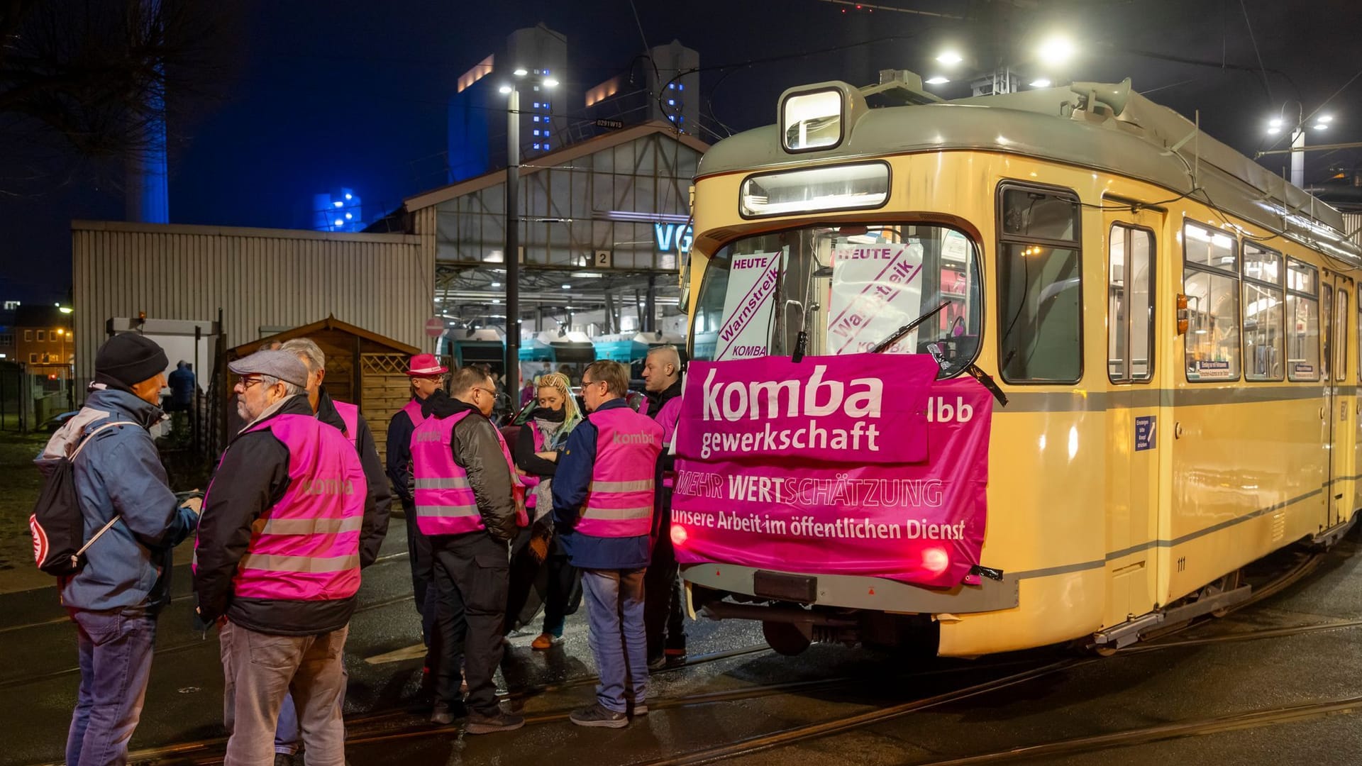 Warnstreikende vor Depot der VGF mit einer alten Straßenbahn und Warnstreik-Banner.