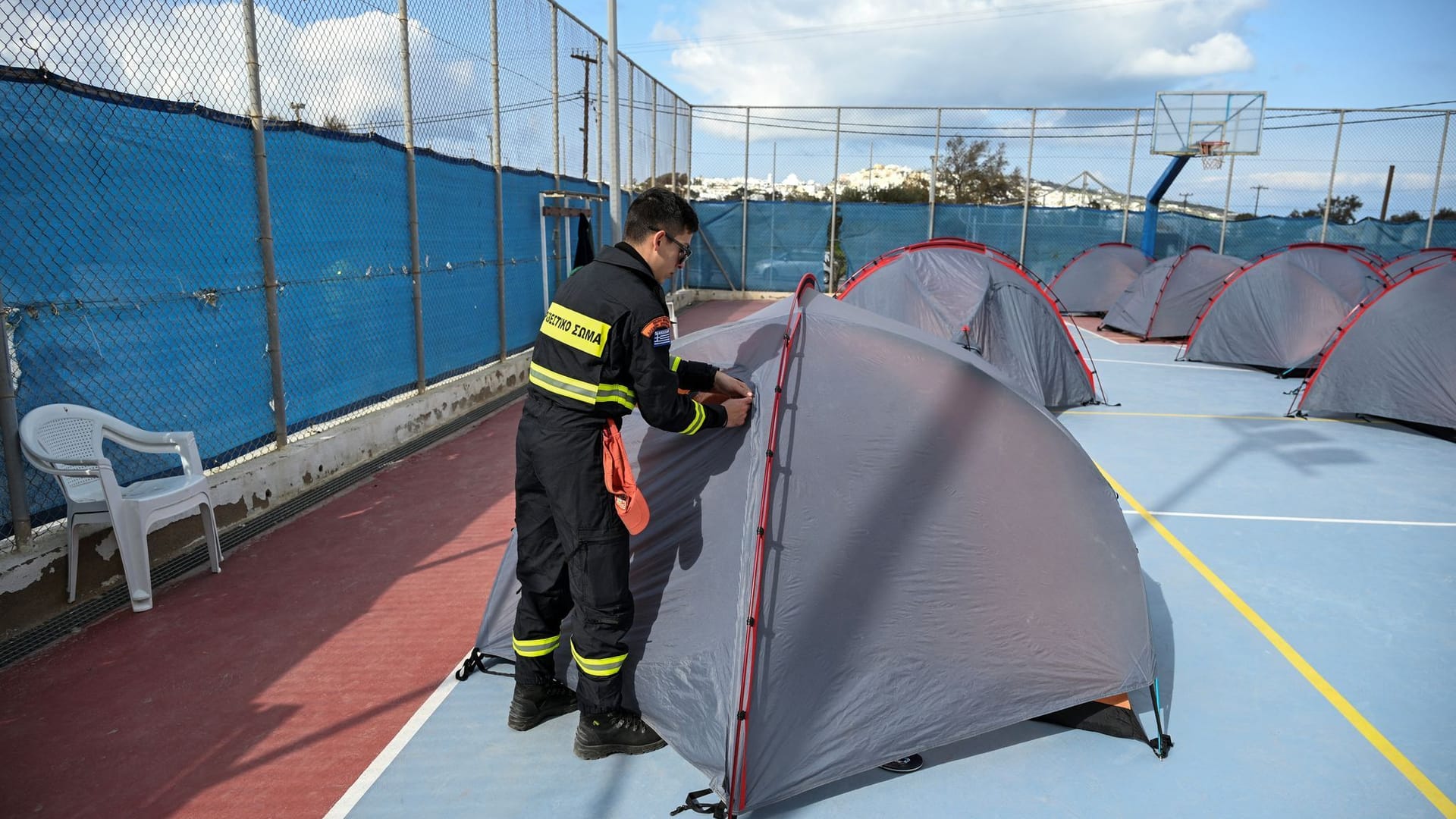 Ein Feuerwehrmann baut ein Zelt auf: Helfer kommen auf die Insel, während die Bewohner fliehen.