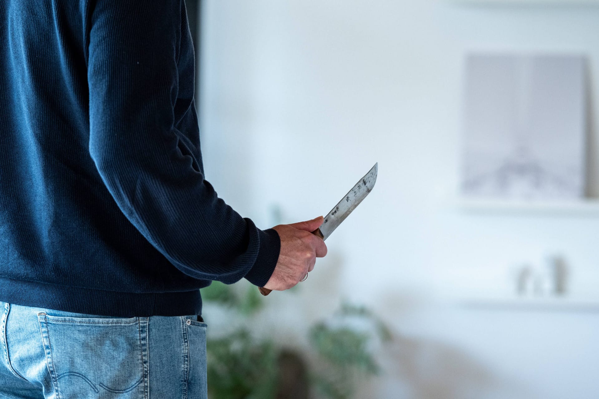 Ein Mann hält ein Messer in der Hand (Archivbild): In Berlin hat die Staatsanwaltschaft Anklage wegen eines mutmaßlichen Femizids erhoben.