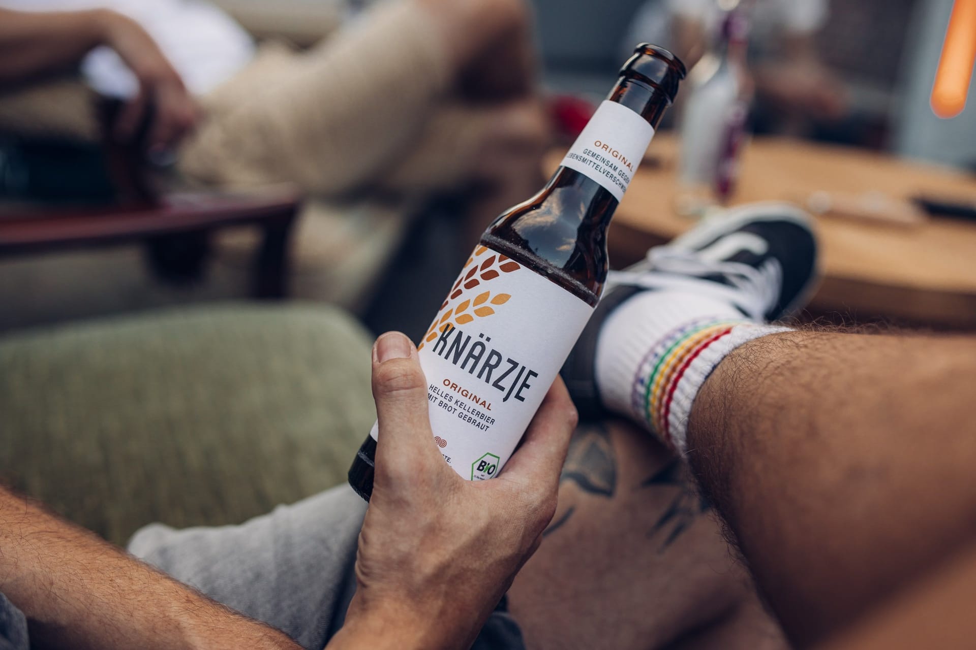 Ein Mann hält eine Flasche Knärzje in der Hand: Momentan läuft der Geschäftsbetrieb noch weitestgehend weiter.