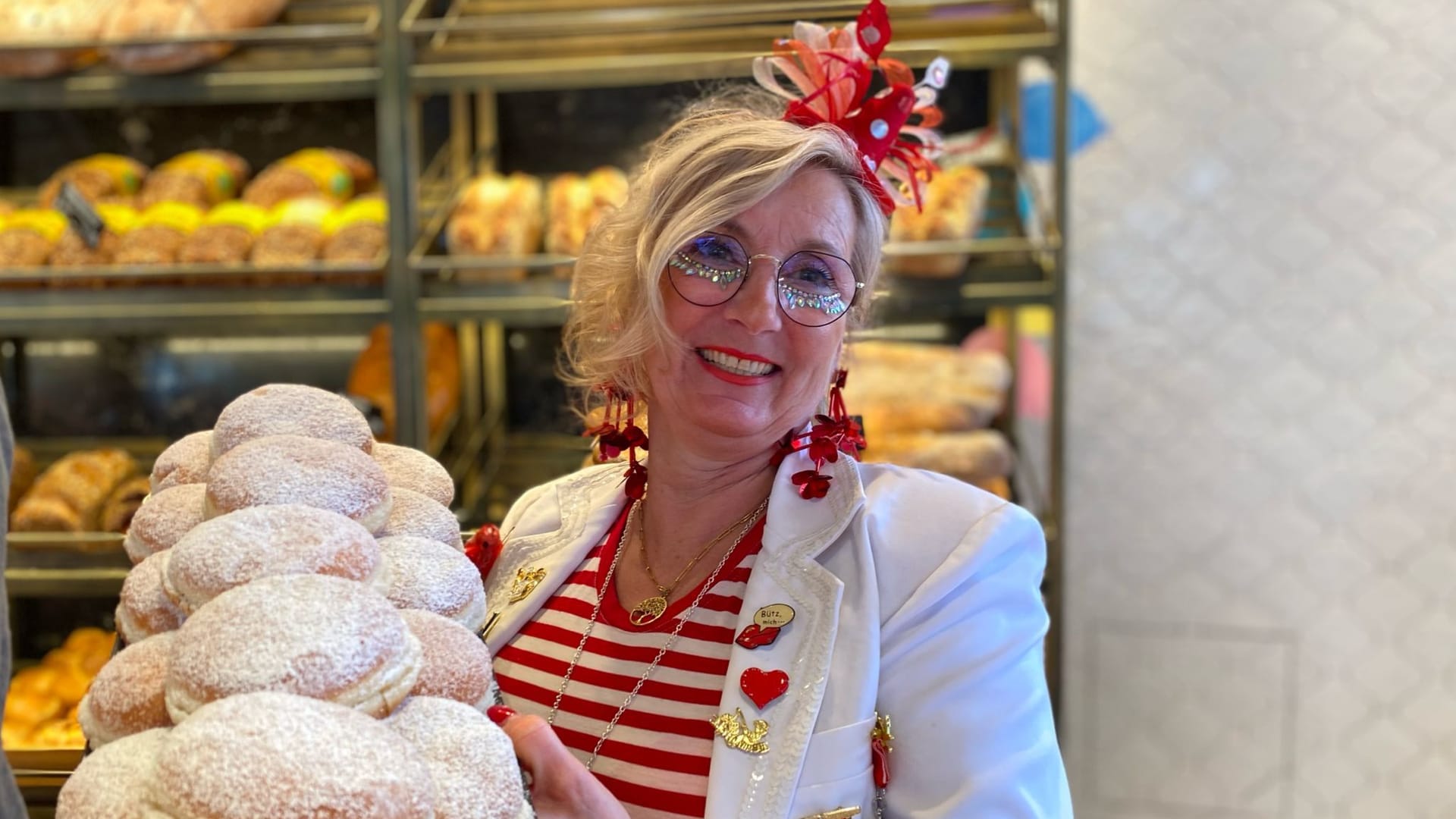 Eine Mitarbeiterin von Nobis hält dutzende Berliner in der Hand.