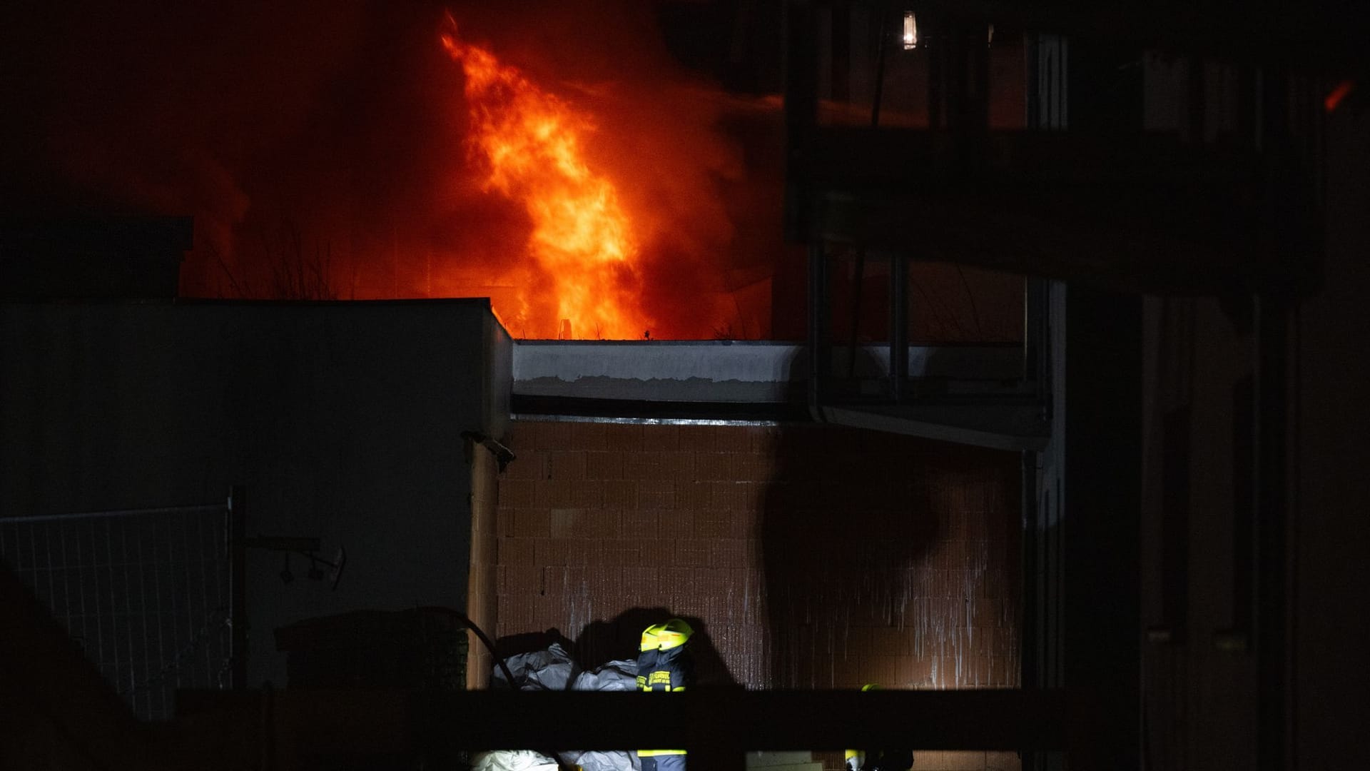 Flammen steigen aus einem Gebäude bei Nacht.